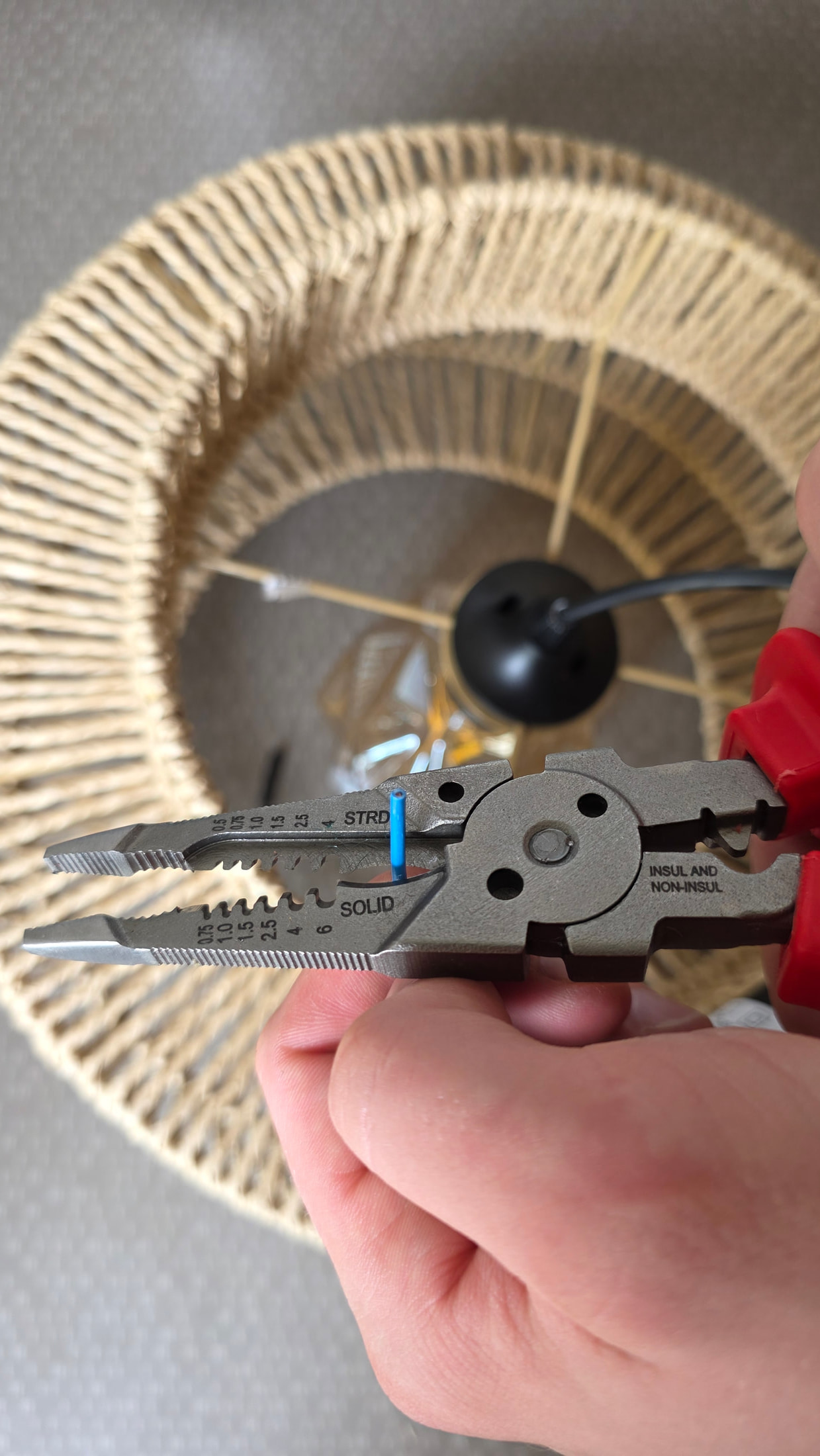 Électricien dénudant l’isolant d’un fil de cuivre avec une pince multifonction C.K Tools