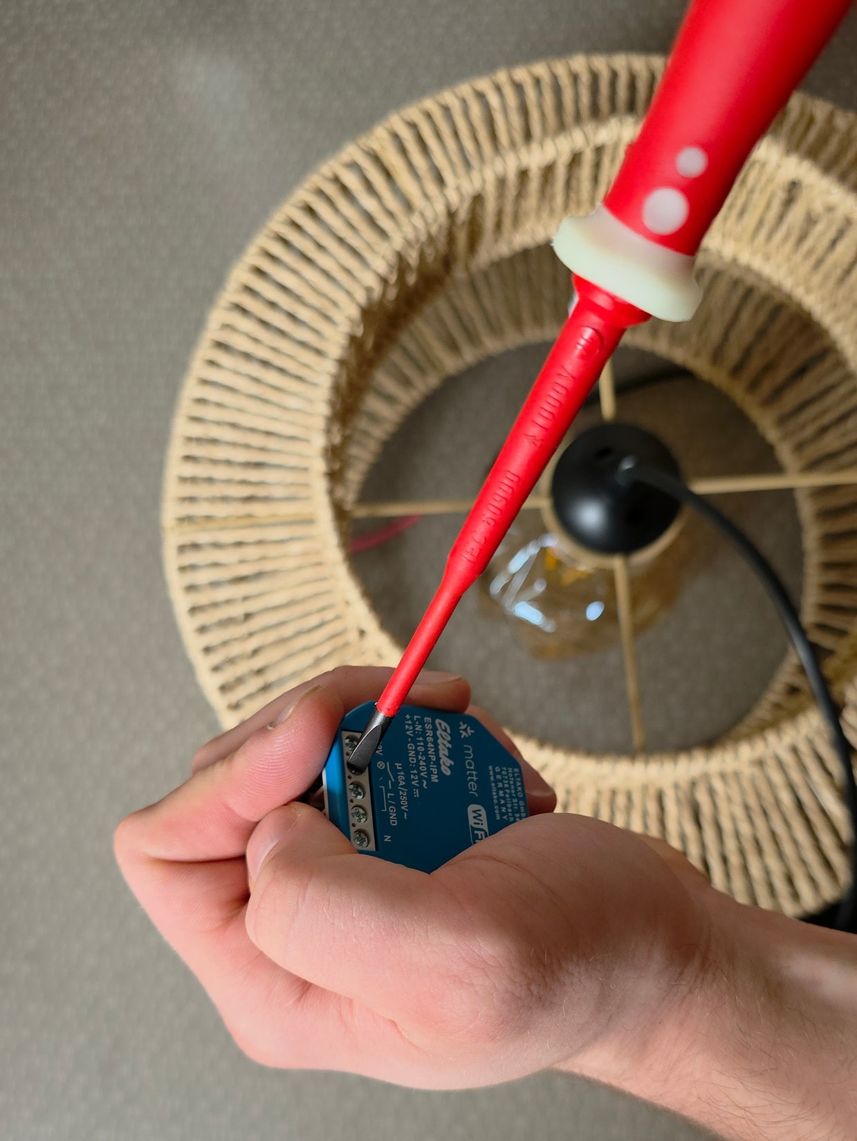 Électricien ajustant le câblage du micromodule Eltako et des bornes Wago 221 avec un tournevis isolé