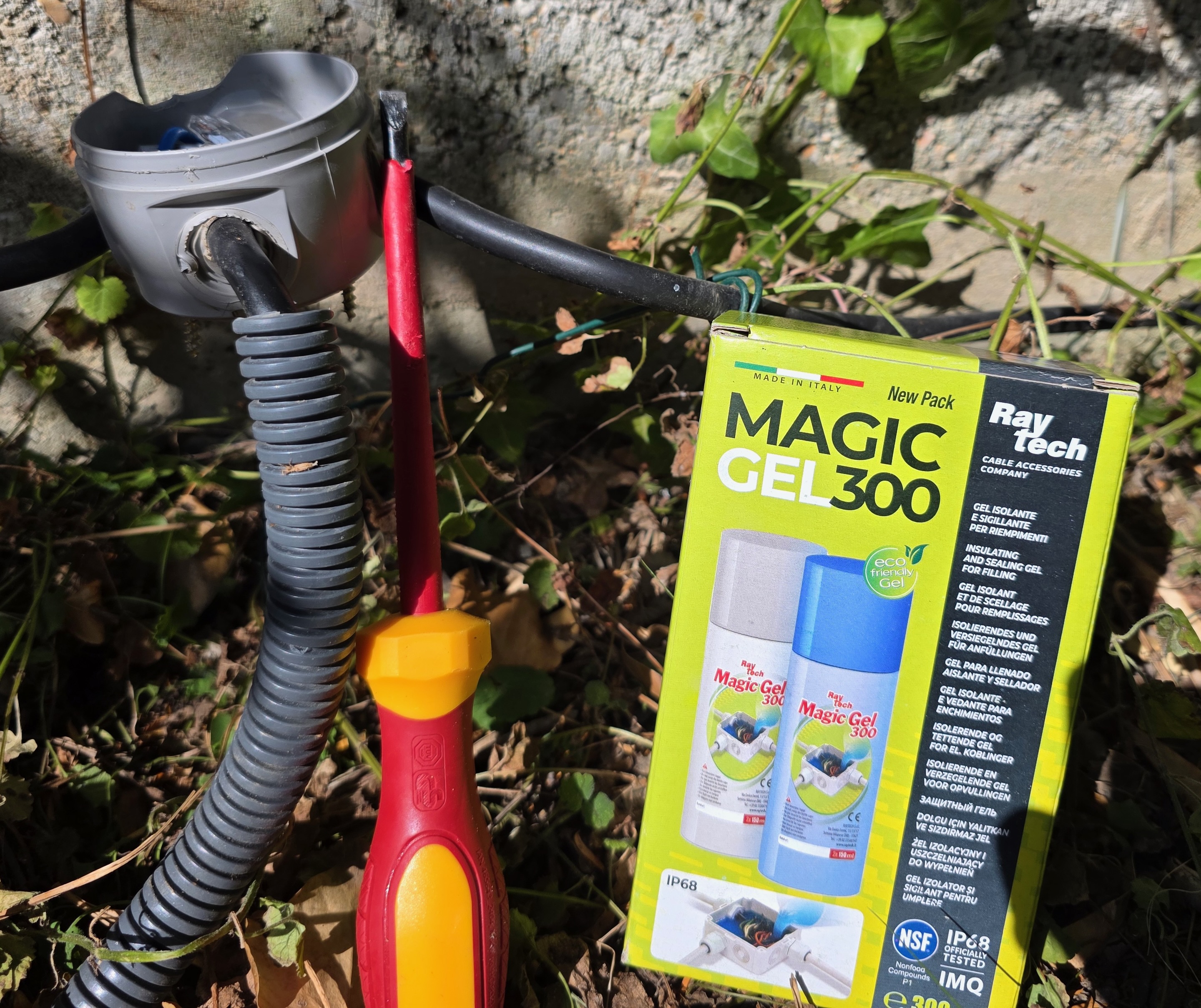 Boîte de Magic Gel 300 Raytech posée près d’une boîte de dérivation et d’un tournevis