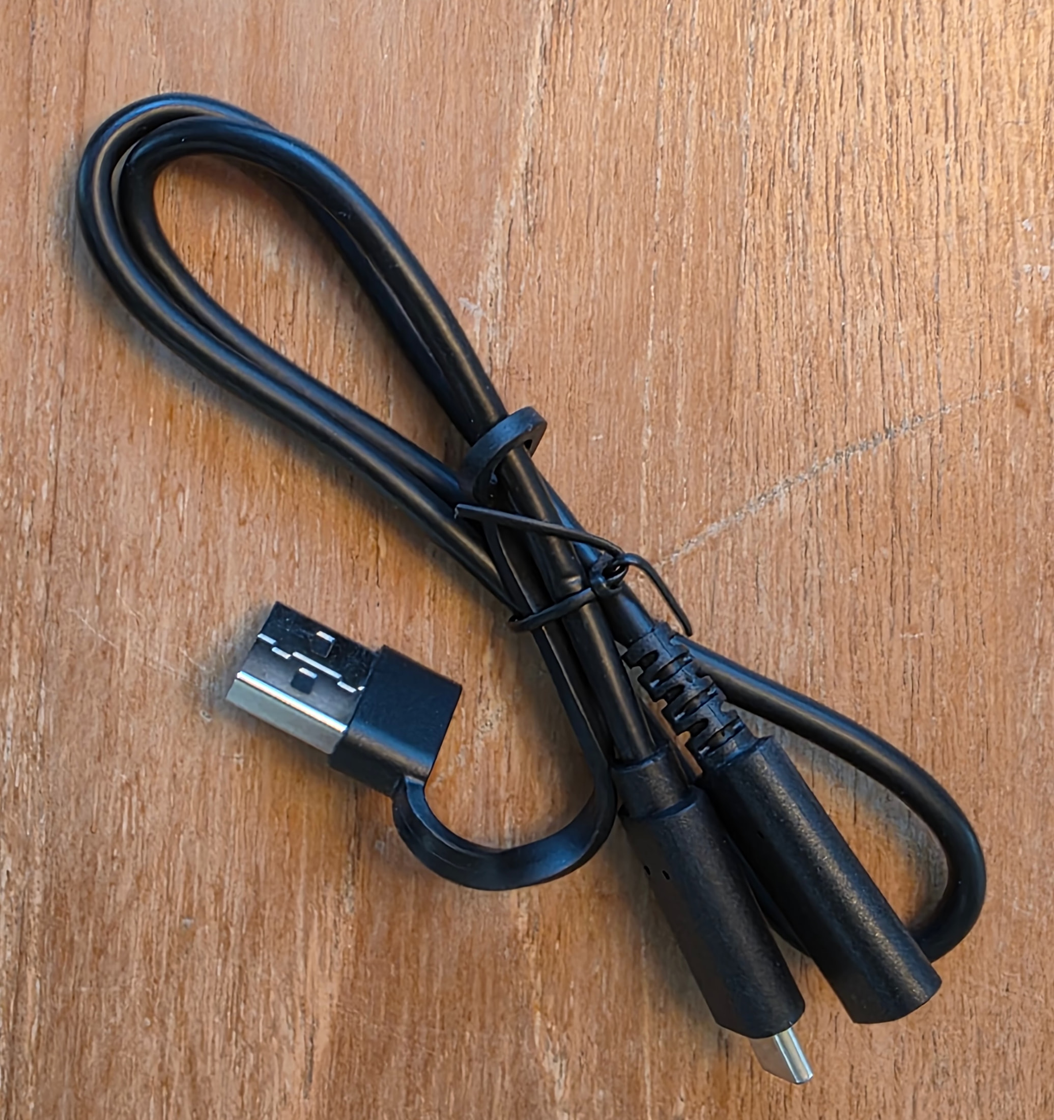 Mit der Thermal Master P3 mitgeliefertes schwarzes USB-Kabel, fotografiert auf einem Holztisch