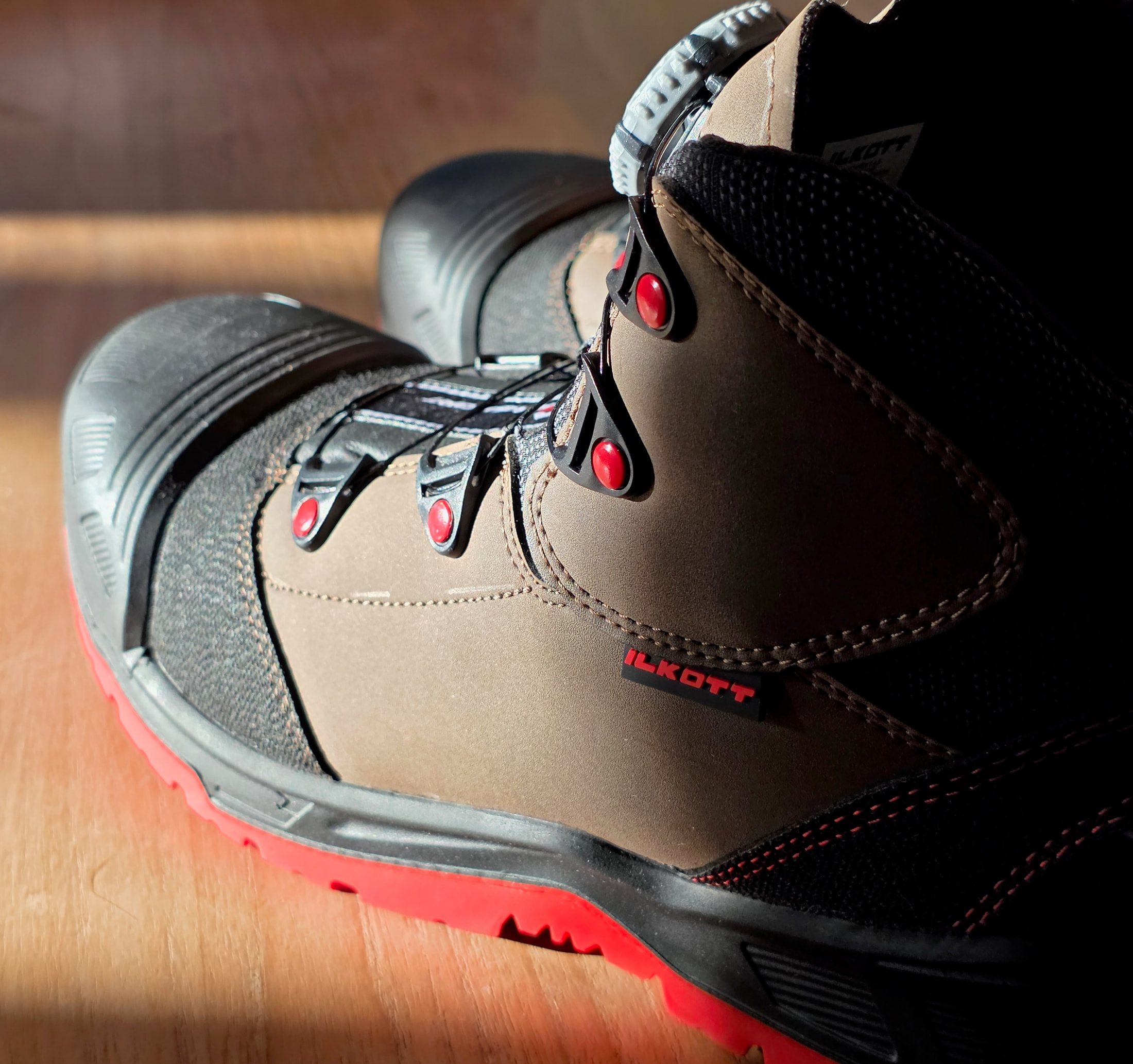 Vue de profil de la chaussure de sécurité Ilkott Mid modèle G, tige marron et noire, semelle rouge et laçage à molette