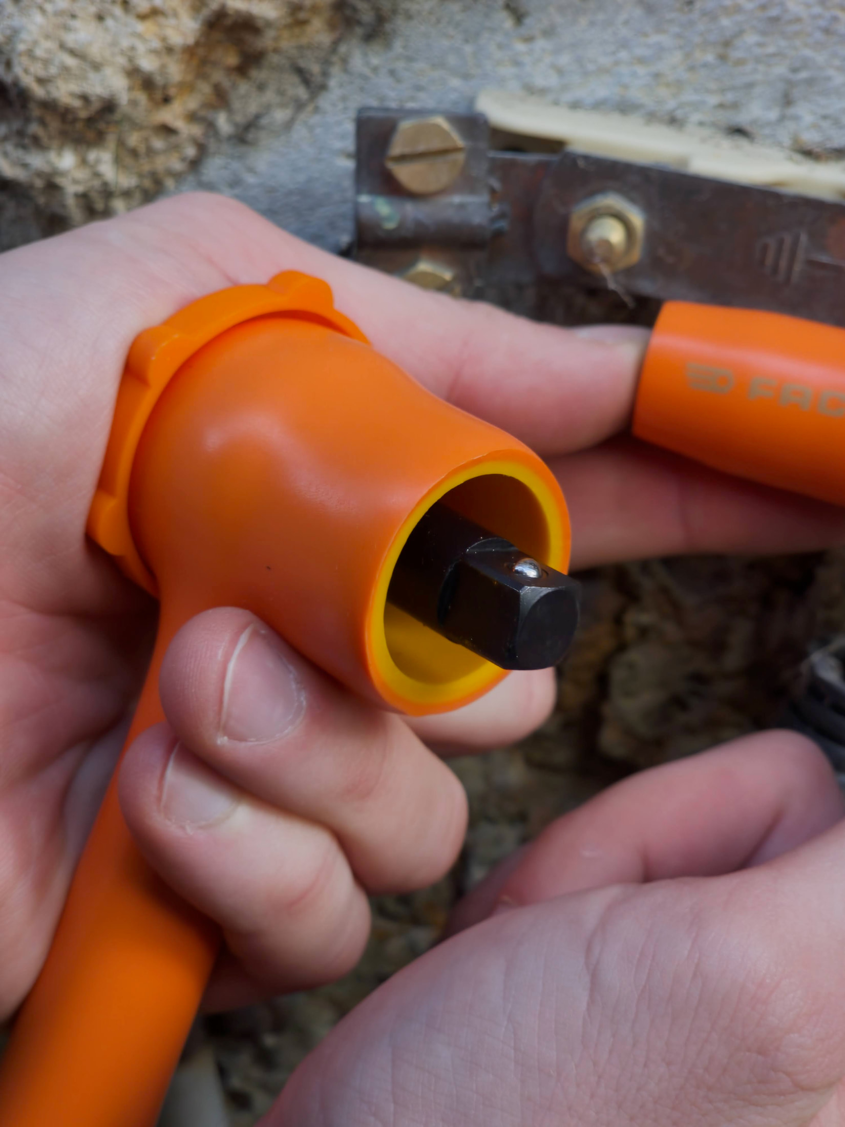 Cliquet FACOM isolé et douille de 10 mm utilisés sur la fixation d'une barrette de terre