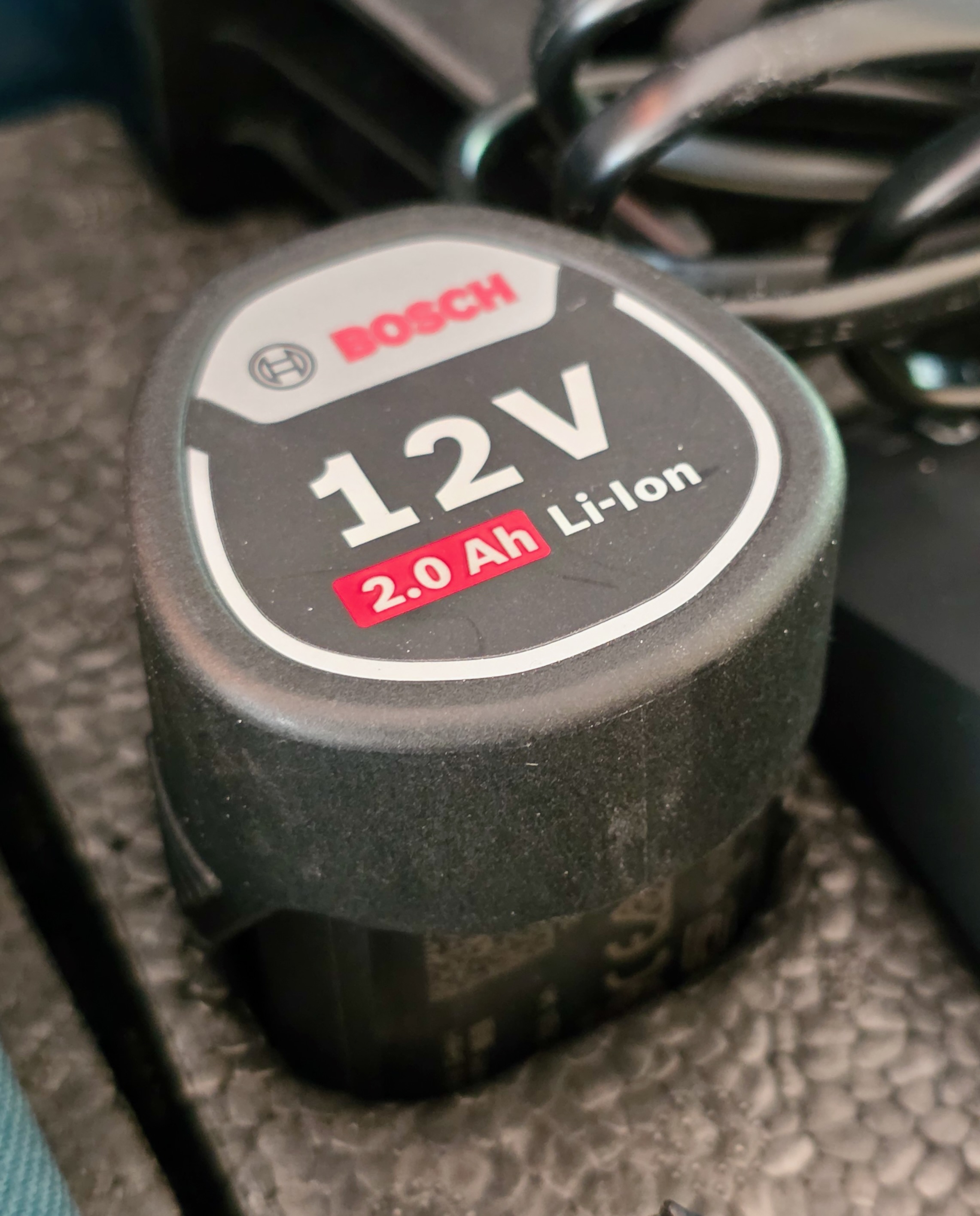 Gros plan d’une batterie Bosch 12 V insérée dans un laser GLL 380
