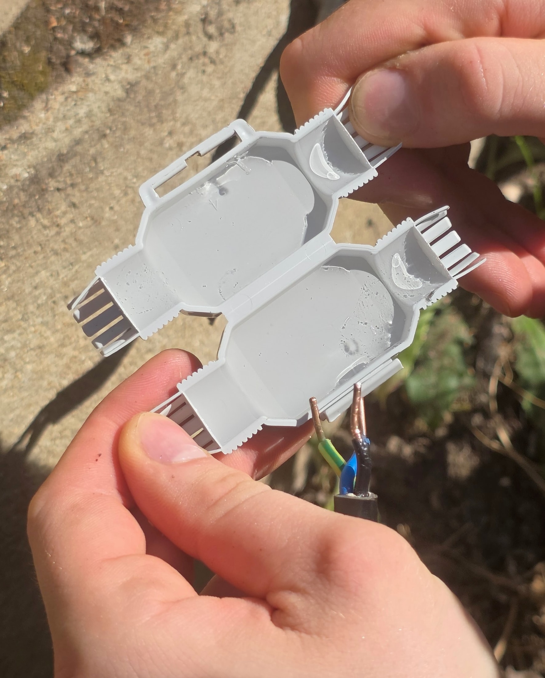 Connecteur Raytech Betty 4 étanche gris ouvert rempli de Magic Gel transparent tenu dans les mains