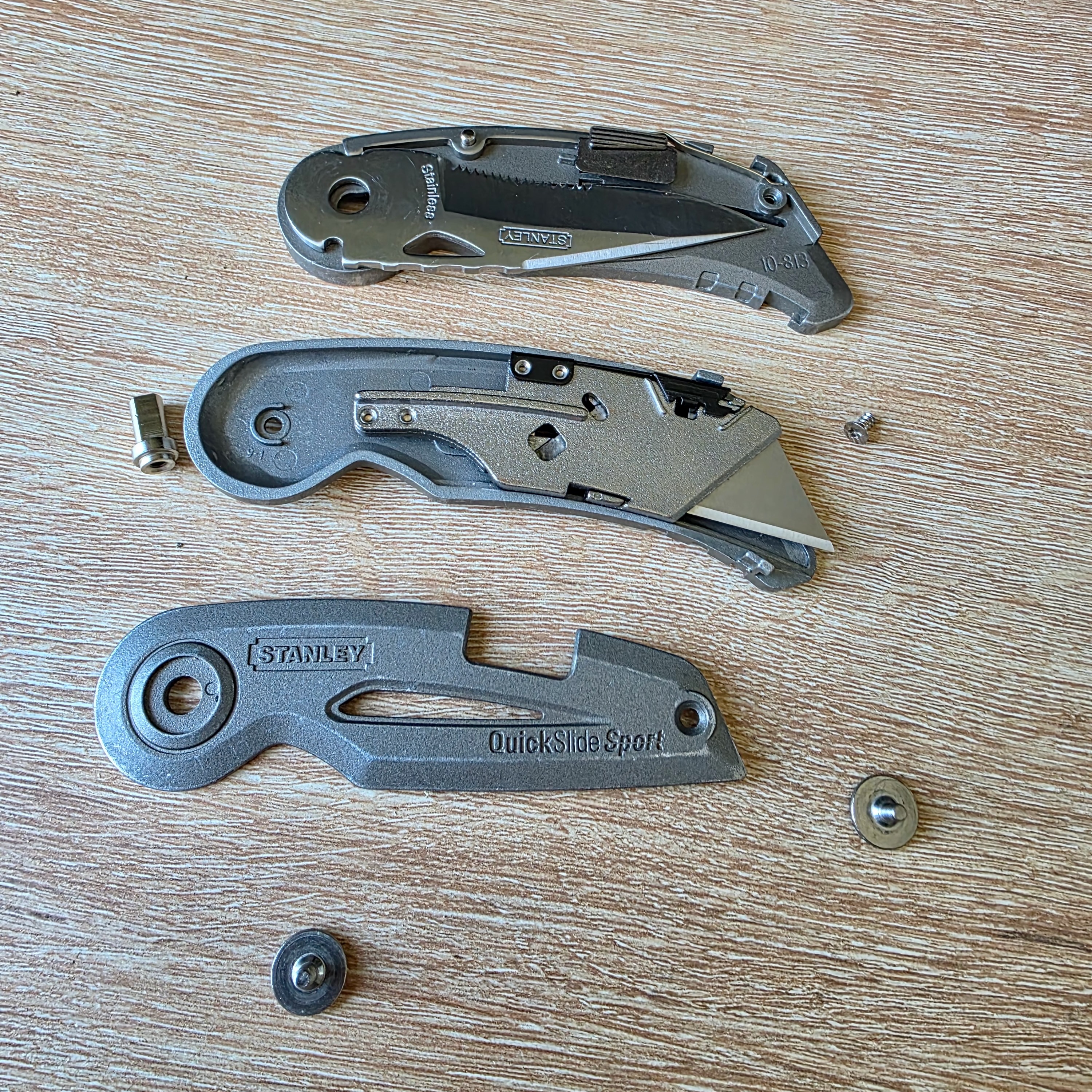 Couteau Stanley Quickslide démonté, posé sur une table