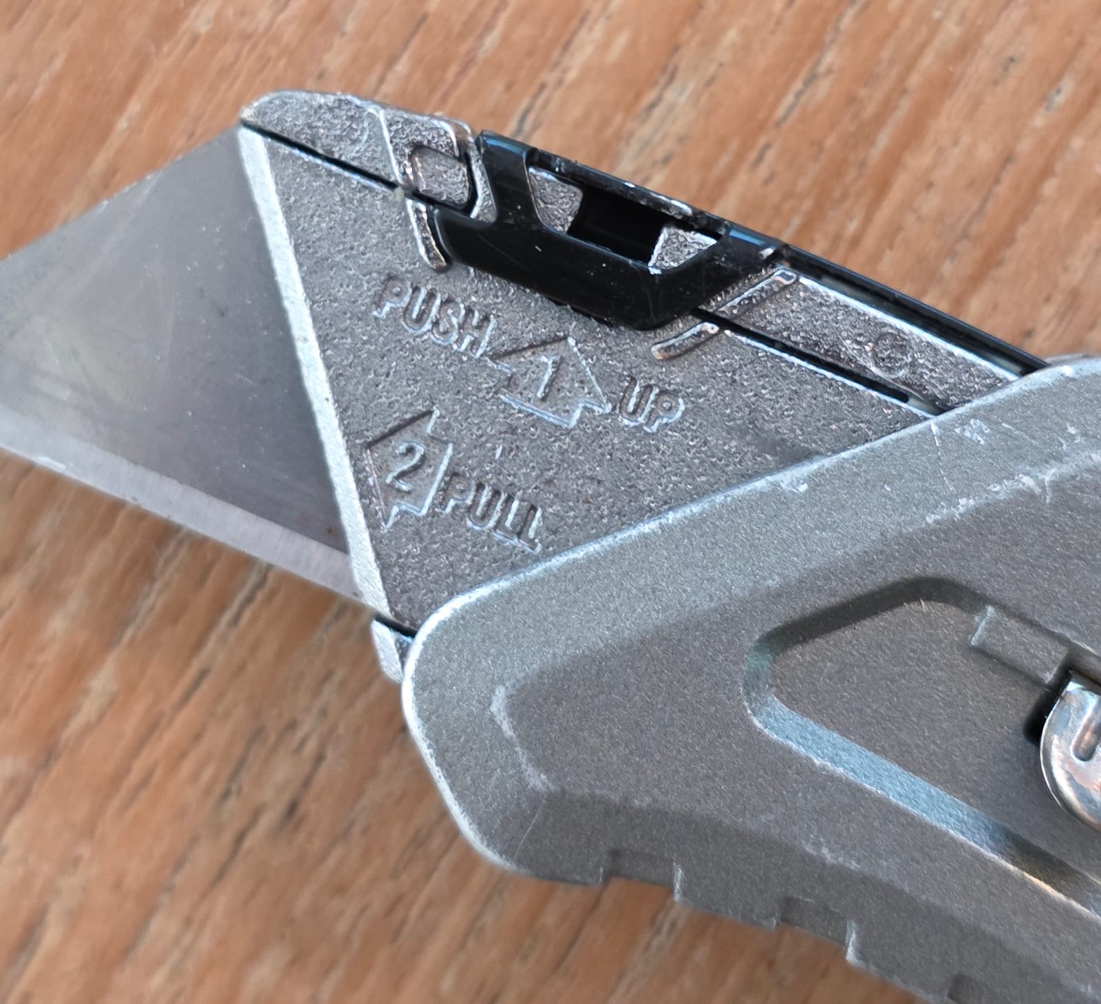 Gros plan sur la lame d’un cutter Stanley QuickSport avec les indications pour changer la lame