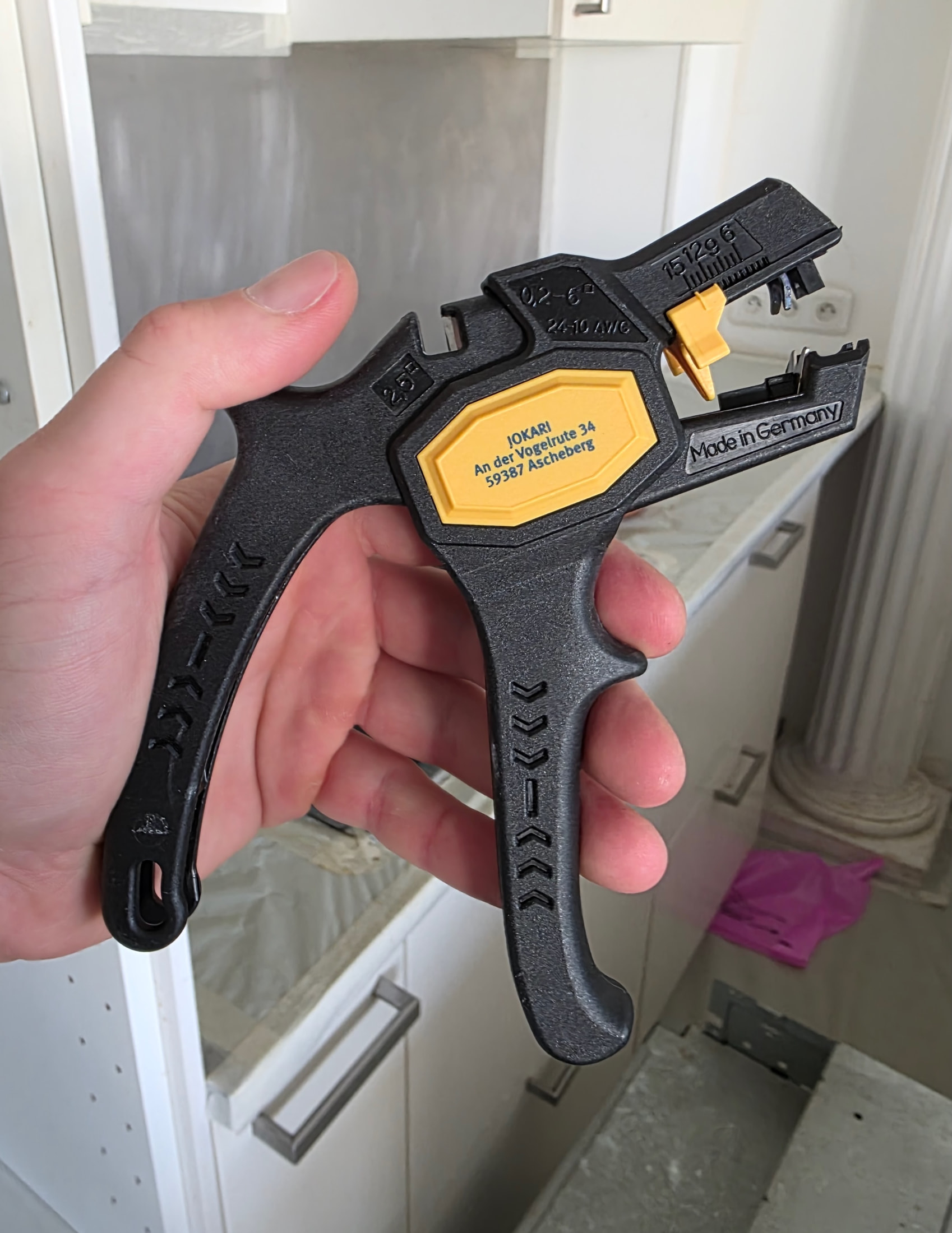 Pince automatique à dénuder Jokari Super 4 Plus noire et jaune tenue en main, gravures techniques visibles