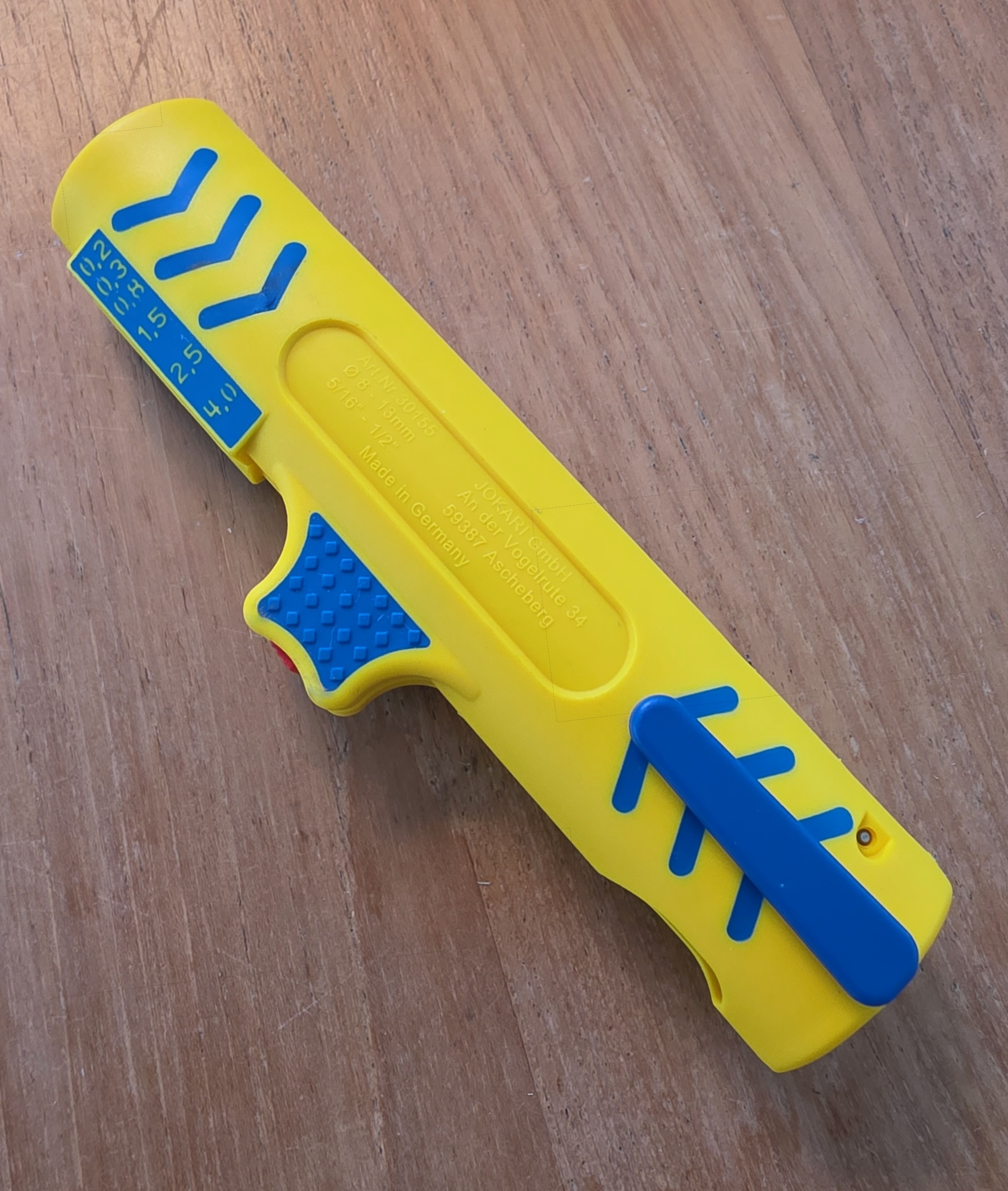 Dos du dénudeur Jokari Secura No. 15 jaune et bleu posé sur un établi, clip de poche visible à l’arrière du corps