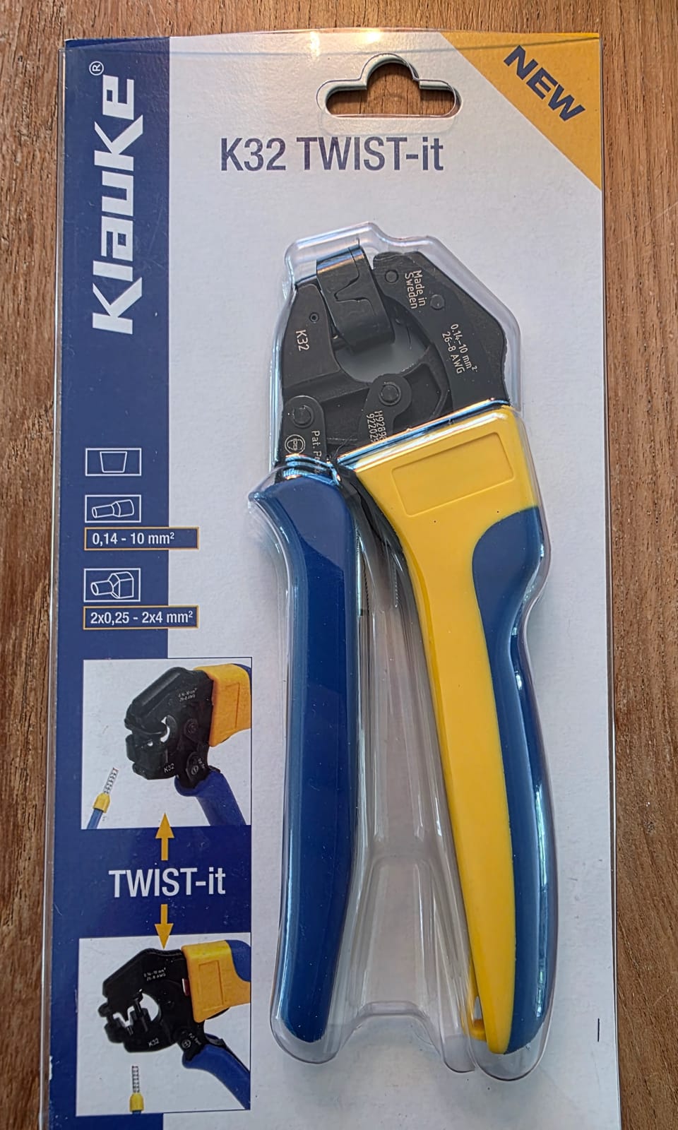 Emballage blister de la pince Klauke K32 TWIST-it posé sur une surface en bois, plages 0,14-10 mm² et 2x0,25-2x4 mm² visibles