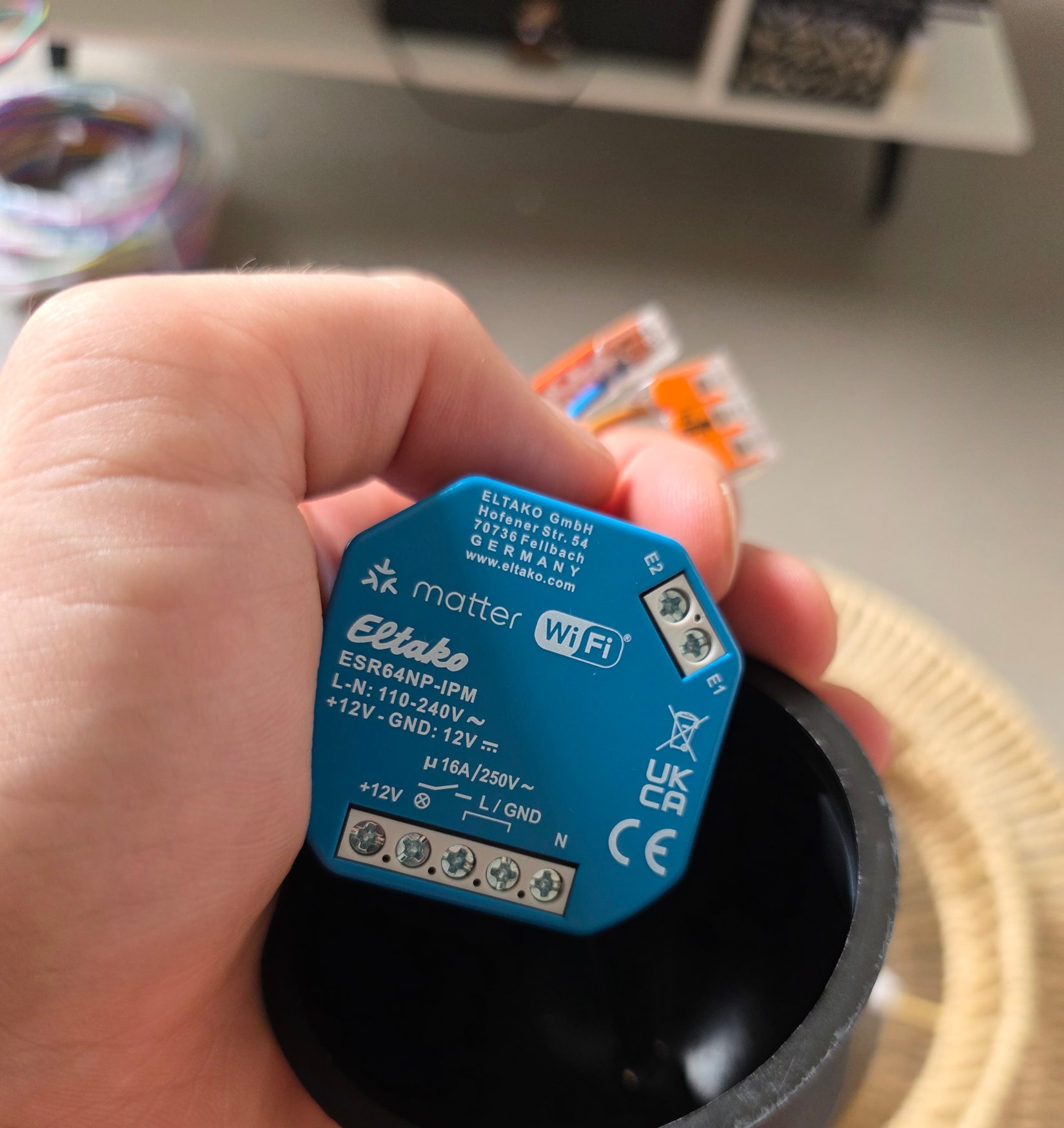 Micromodule Eltako ESR64NP-IPM tenu en main, montrant son étiquette, son bornier et le marquage matter WiFi.