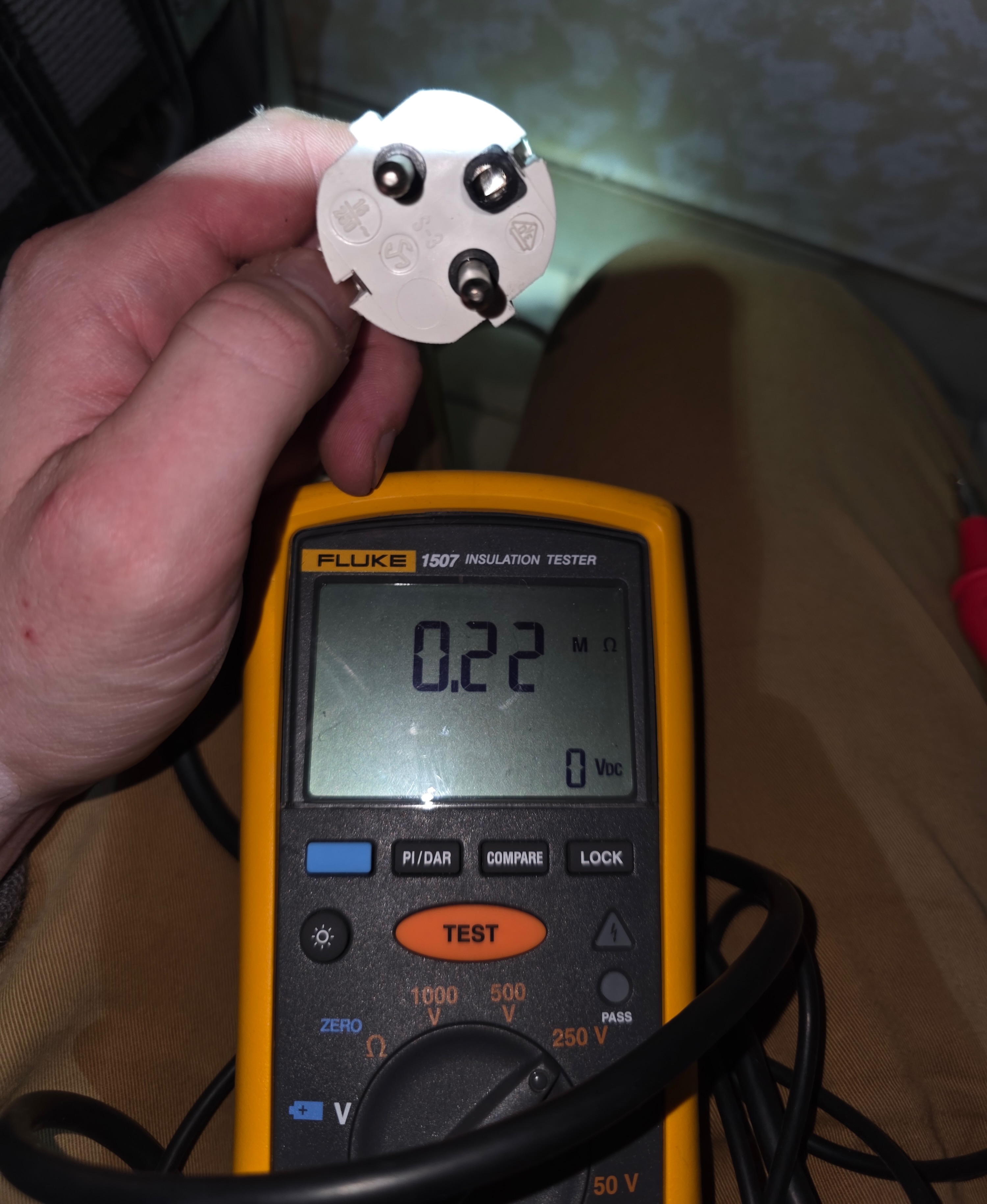 Écran du Fluke 1507 affichant 0,22 MΩ sous une tension d’essai de 1 000 V, sur une fiche secteur