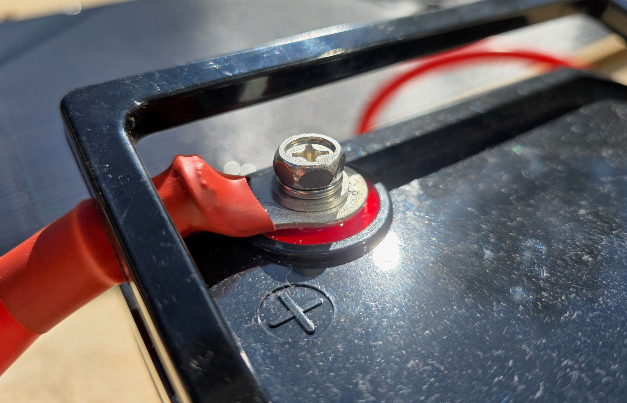Gros plan sur la borne positive de la batterie ECO-WORTHY avec le câble rouge connecté