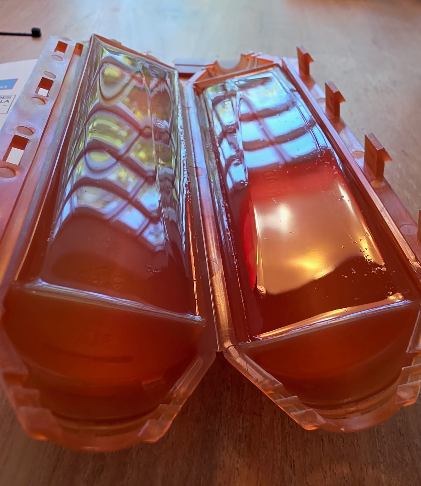 Intérieur des coques orange Ready Cast remplies d’une résine gel transparente avec des reflets