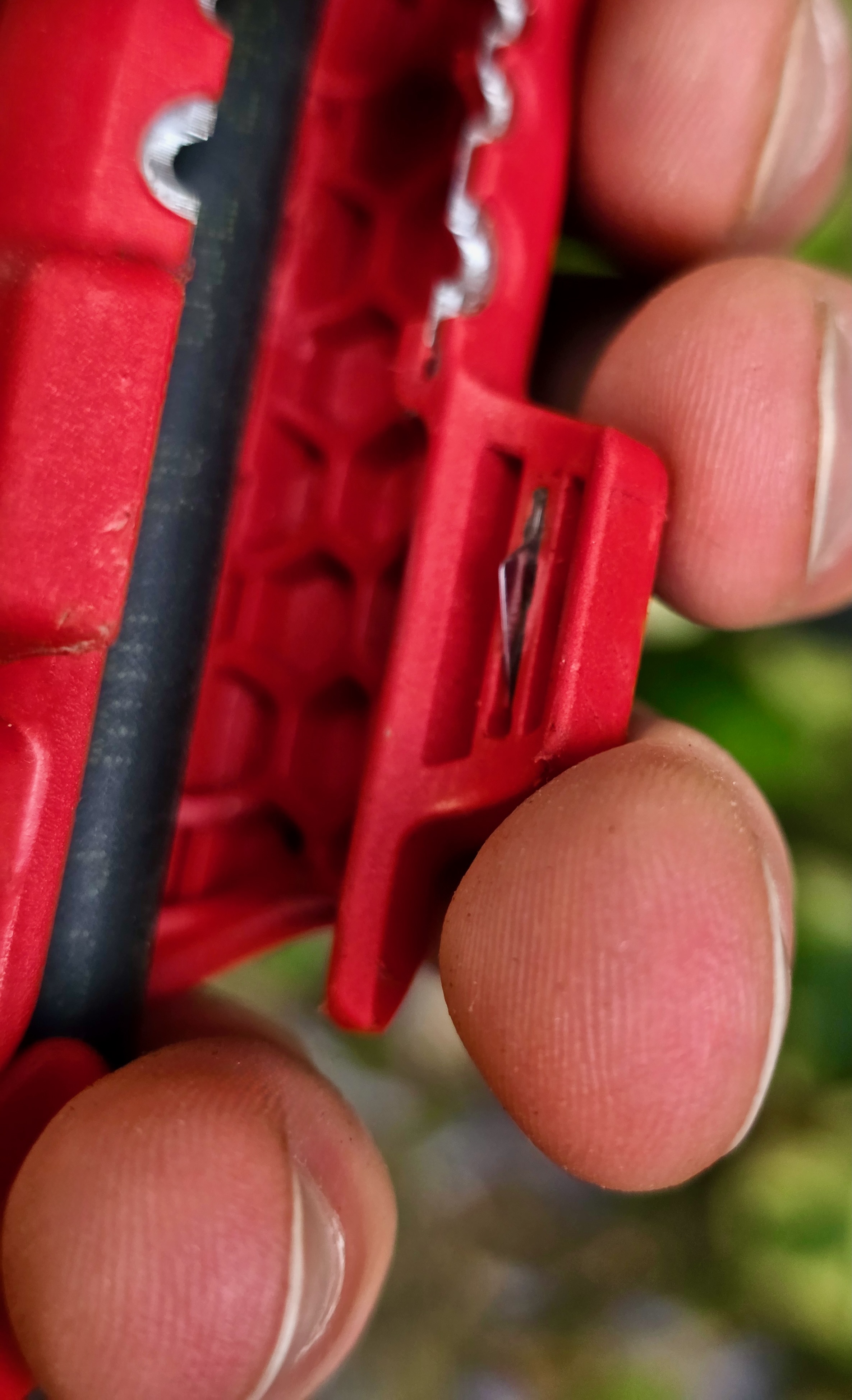 Knipex ErgoStrip tenue en main pendant le dénudage d’un câble, gros plan sur la lame