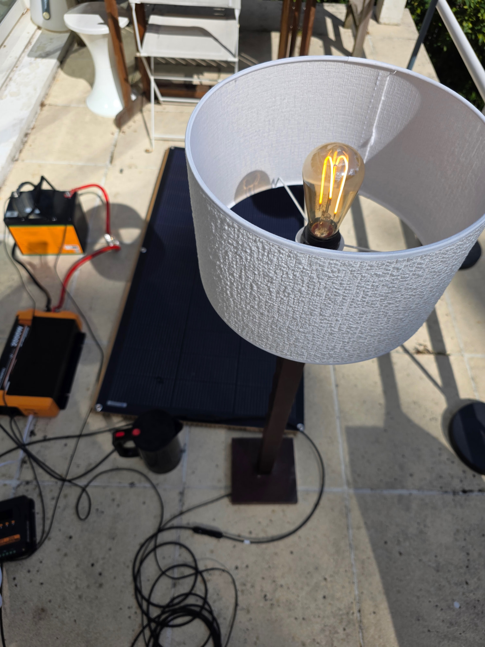 Lampe à abat-jour blanc avec ampoule LED et bouilloire allumées, alimentées par le kit solaire ECO-WORTHY