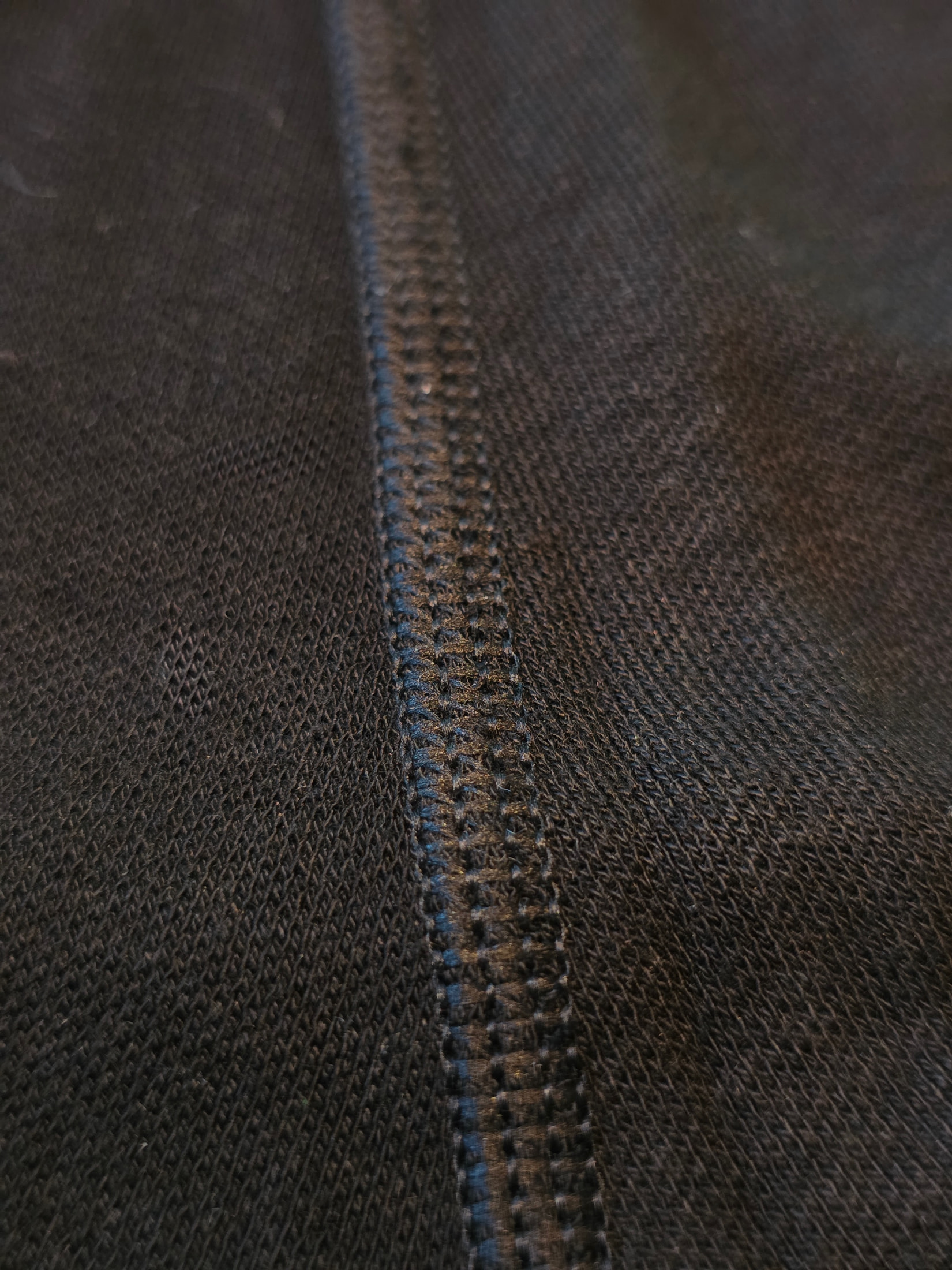 Makroaufnahme der Overlock-Naht auf dem schwarzen, engmaschigen Stoff der Ilkott-Thermounterhose