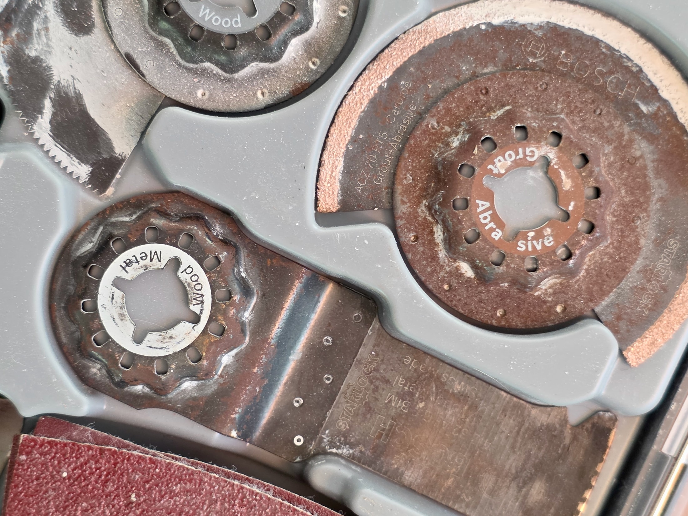 Plusieurs lames Starlock usagées de types bois, métal et ciment, dans une malette