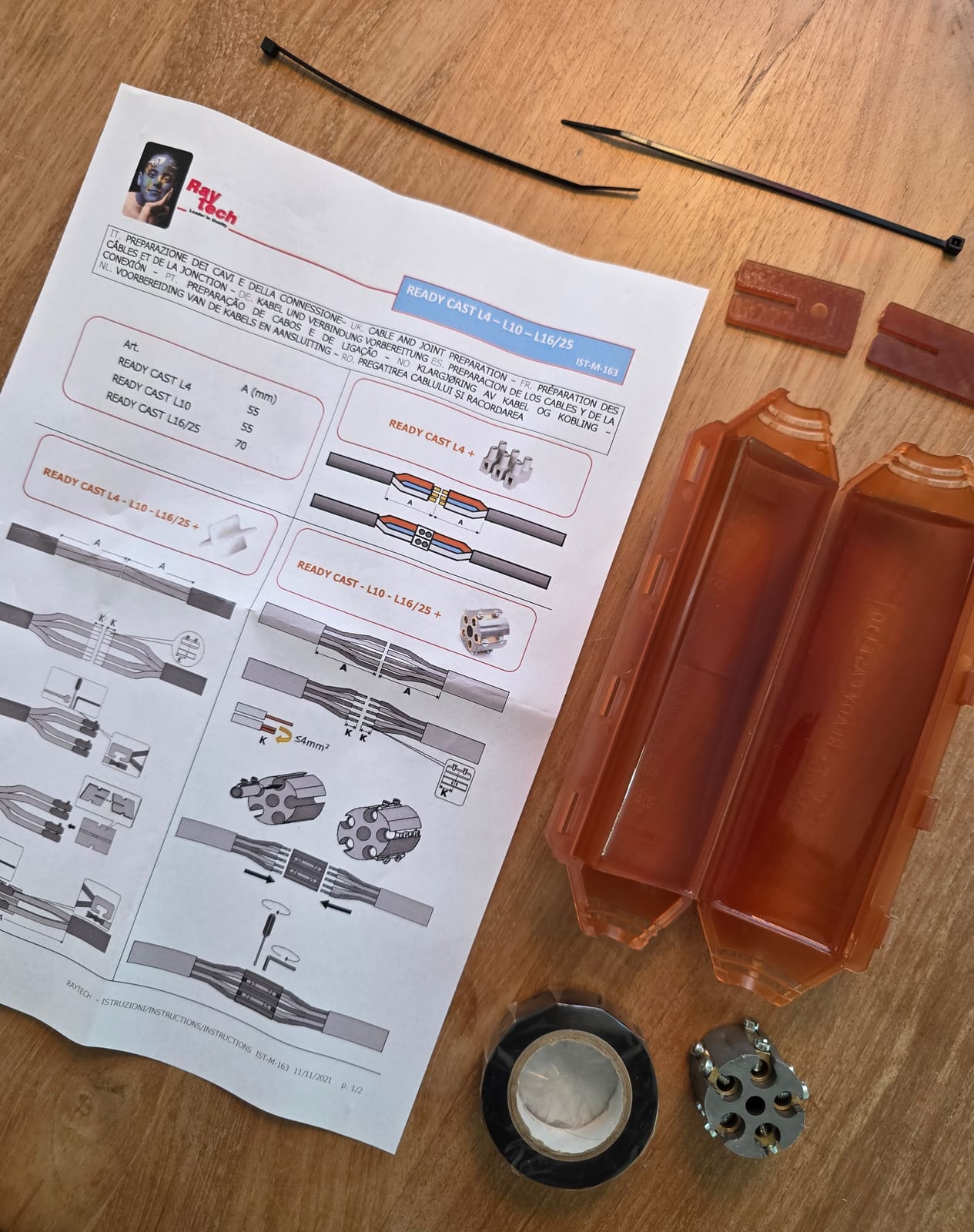 Notice de la gamme Ready Cast L4, L10 et L16/25 posée avec les composants du kit sur une table en bois