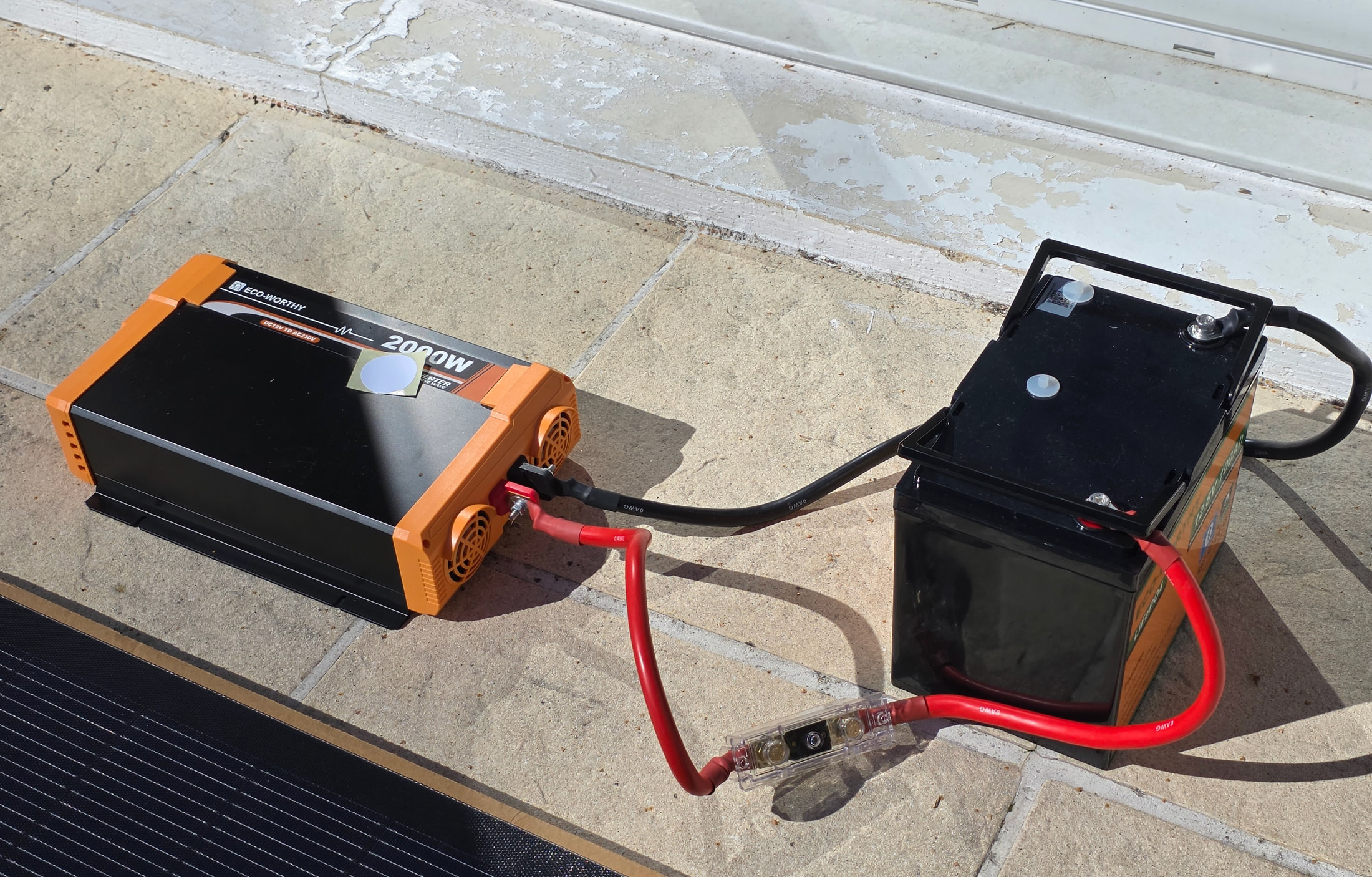 Onduleur ECO-WORTHY 2000 W et batterie lithium reliés par les câbles rouge et noir