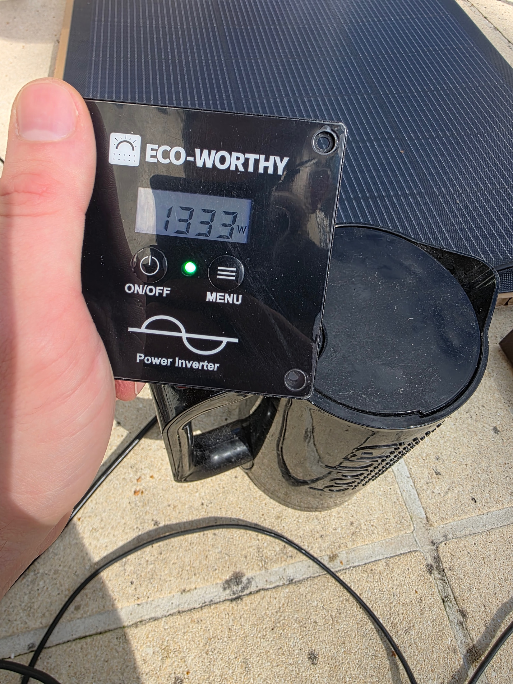 Panneau de contrôle de l’onduleur ECO-WORTHY affichant 1333 W devant la bouilloire et le panneau solaire
