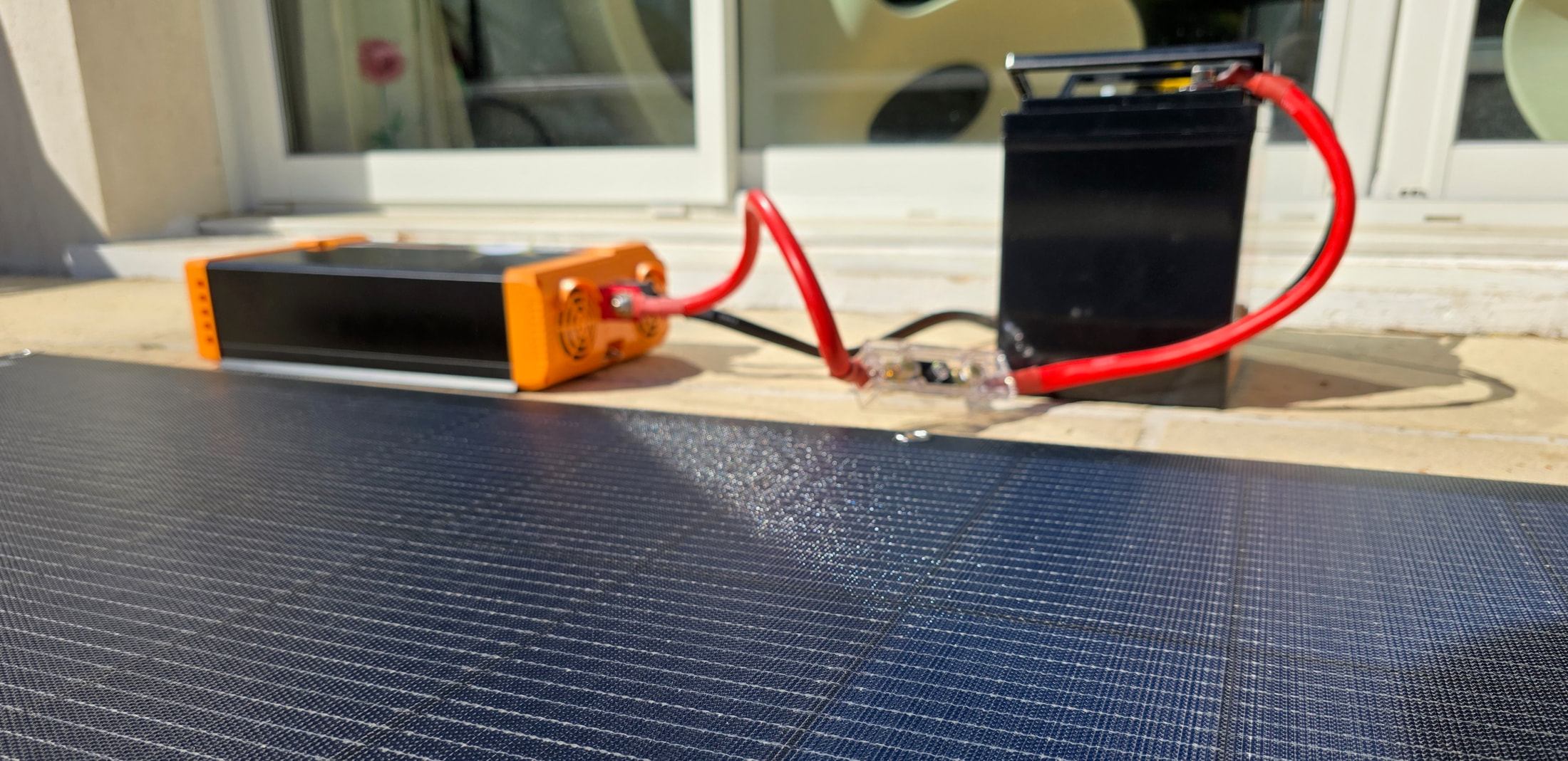 Panneau solaire ECO-WORTHY au premier plan avec onduleur et batterie en arrière-plan