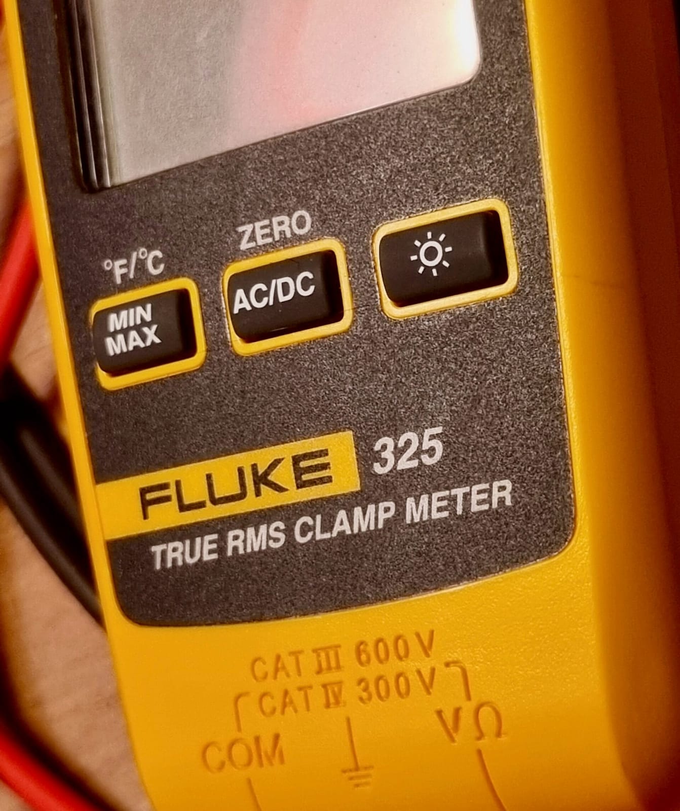 Pince ampèremétrique Fluke 325 en gros plan avec sélecteur rotatif et cordons de mesure