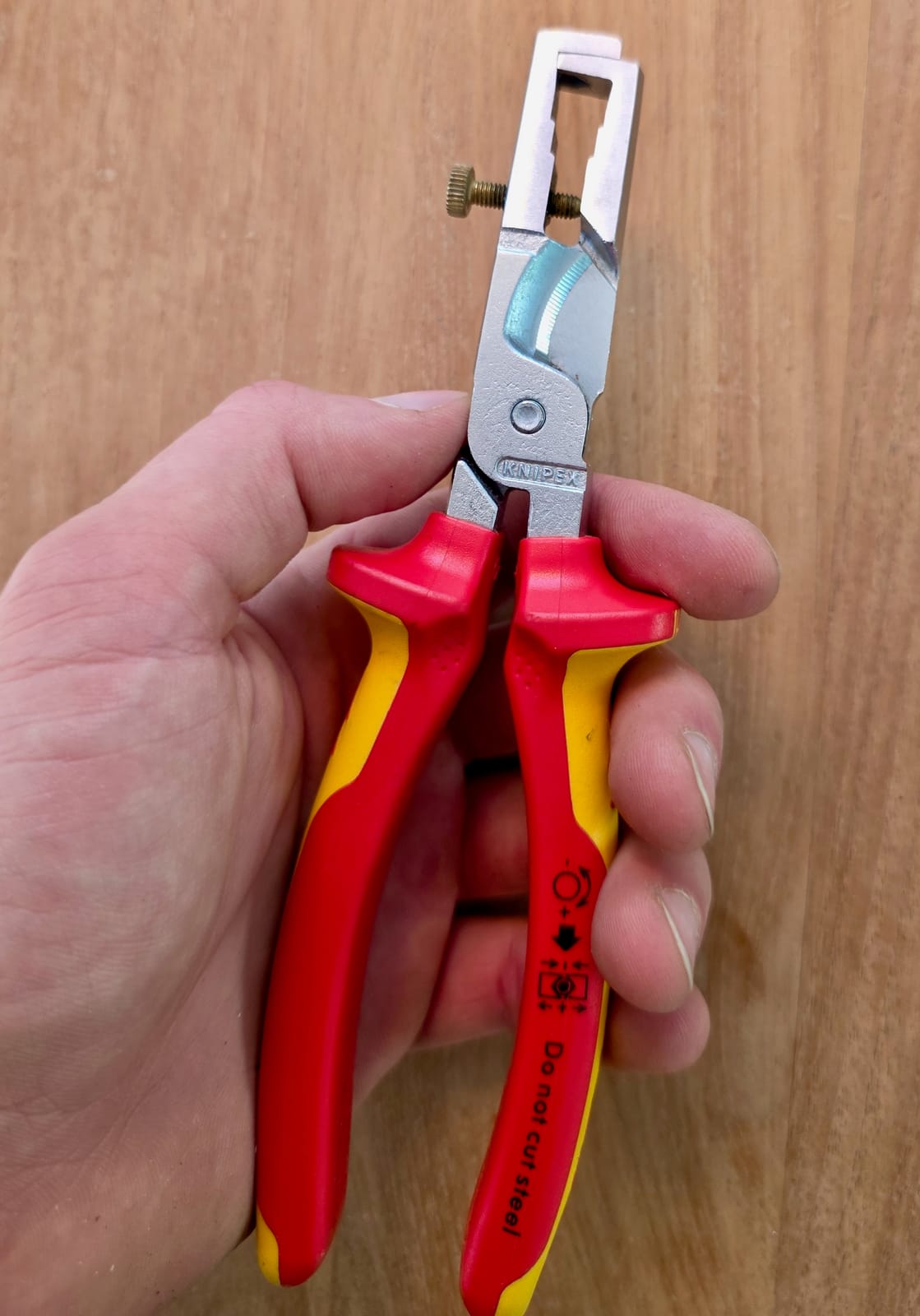 Pince à dénuder Knipex 13 66 180 VDE tenue en main, poignées jaune et rouge