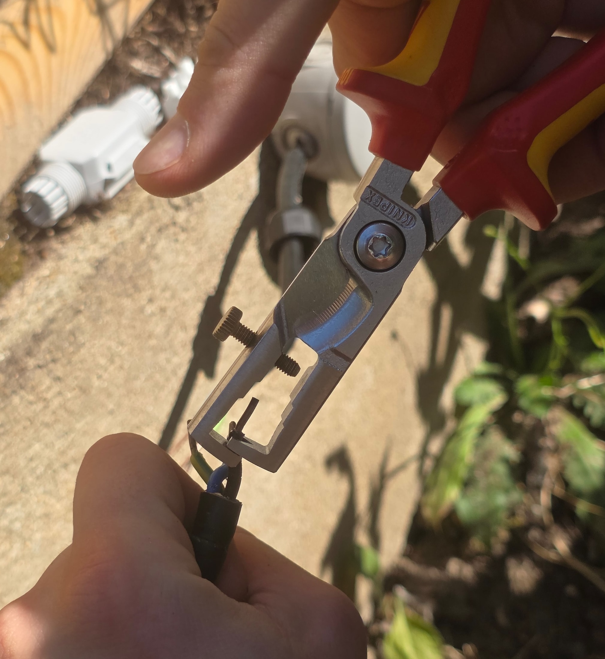 Pince à dénuder Knipex VDE en action sur un câble électrique, fil de phase brûlé par un ancien connecteur Amazon bas de gamme