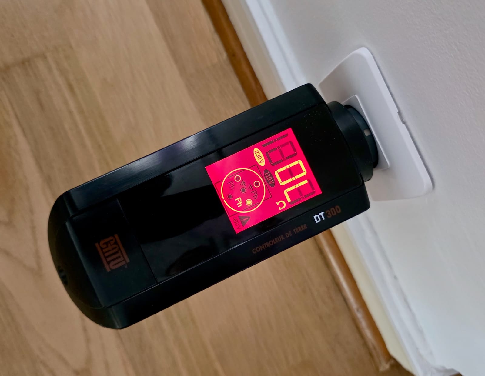 Contrôleur CATU DT-300 sur une prise, écran rouge affichant une valeur hors limite