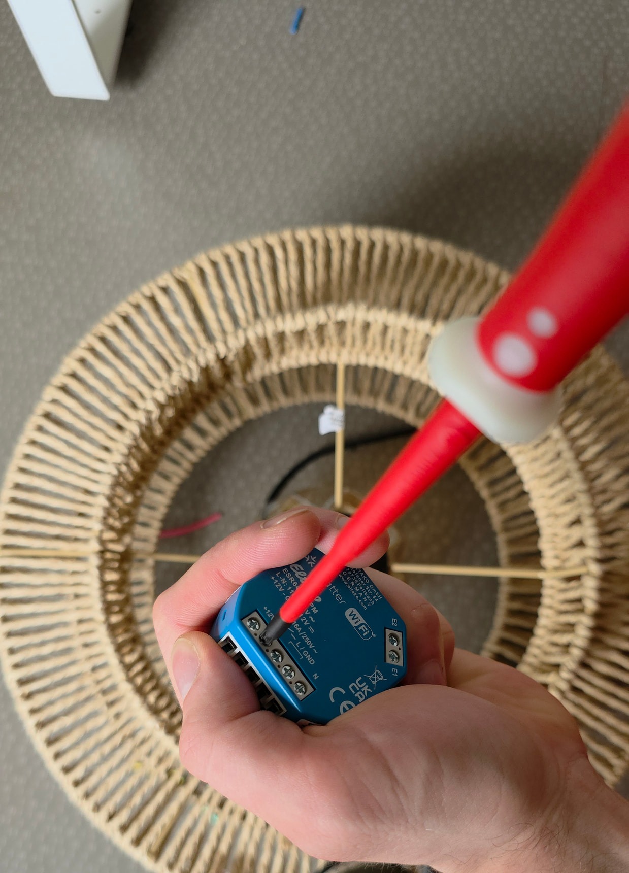 Serrage d’un conducteur sur le bornier du micromodule Eltako avec un tournevis isolé
