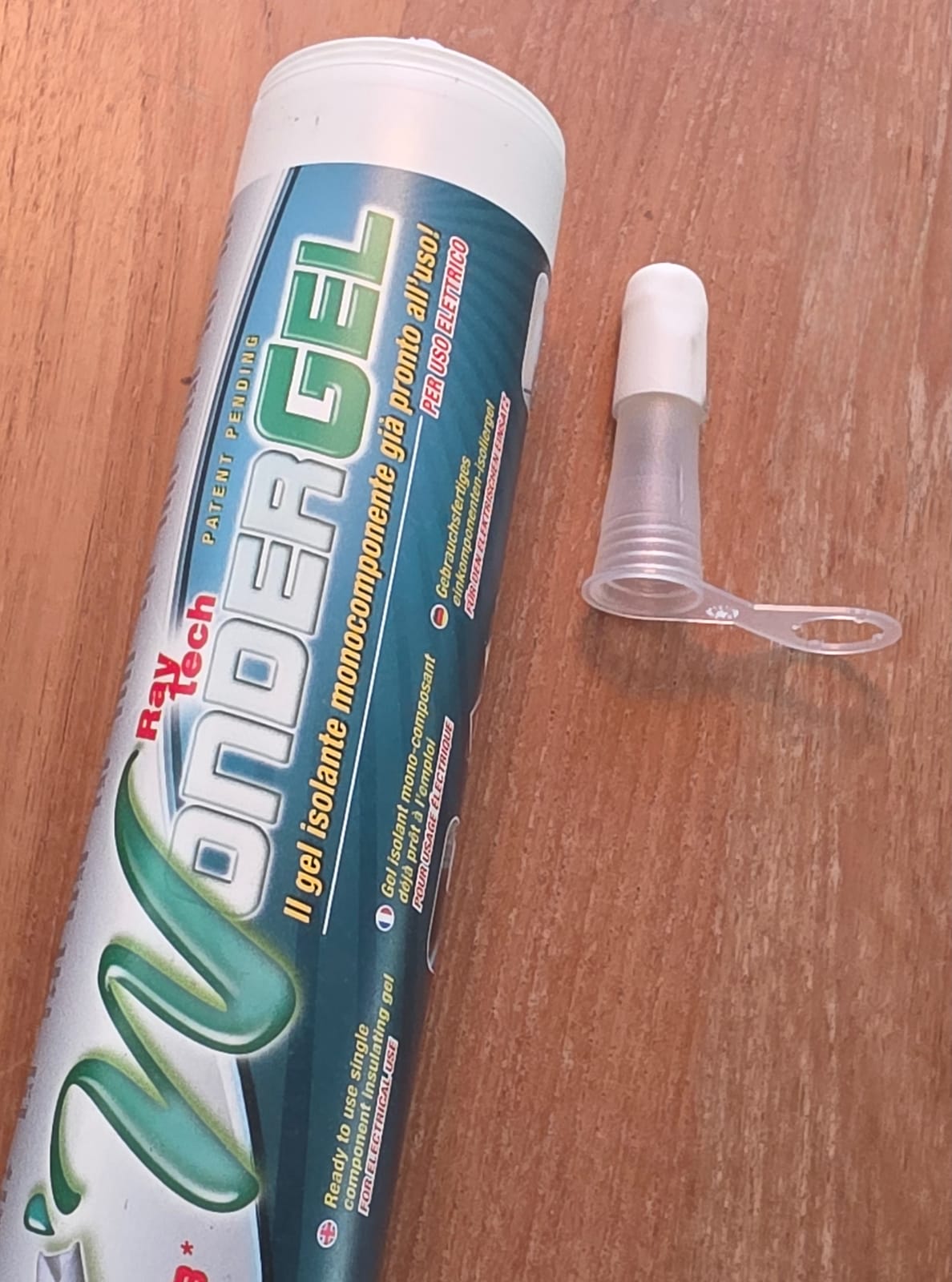 Cartouche de Wonder Gel Raytech posée sur une table en bois avec son embout applicateur blanc détaché