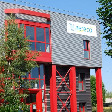 Bâtiment Aereco avec enseigne bleue et architecture rouge et grise