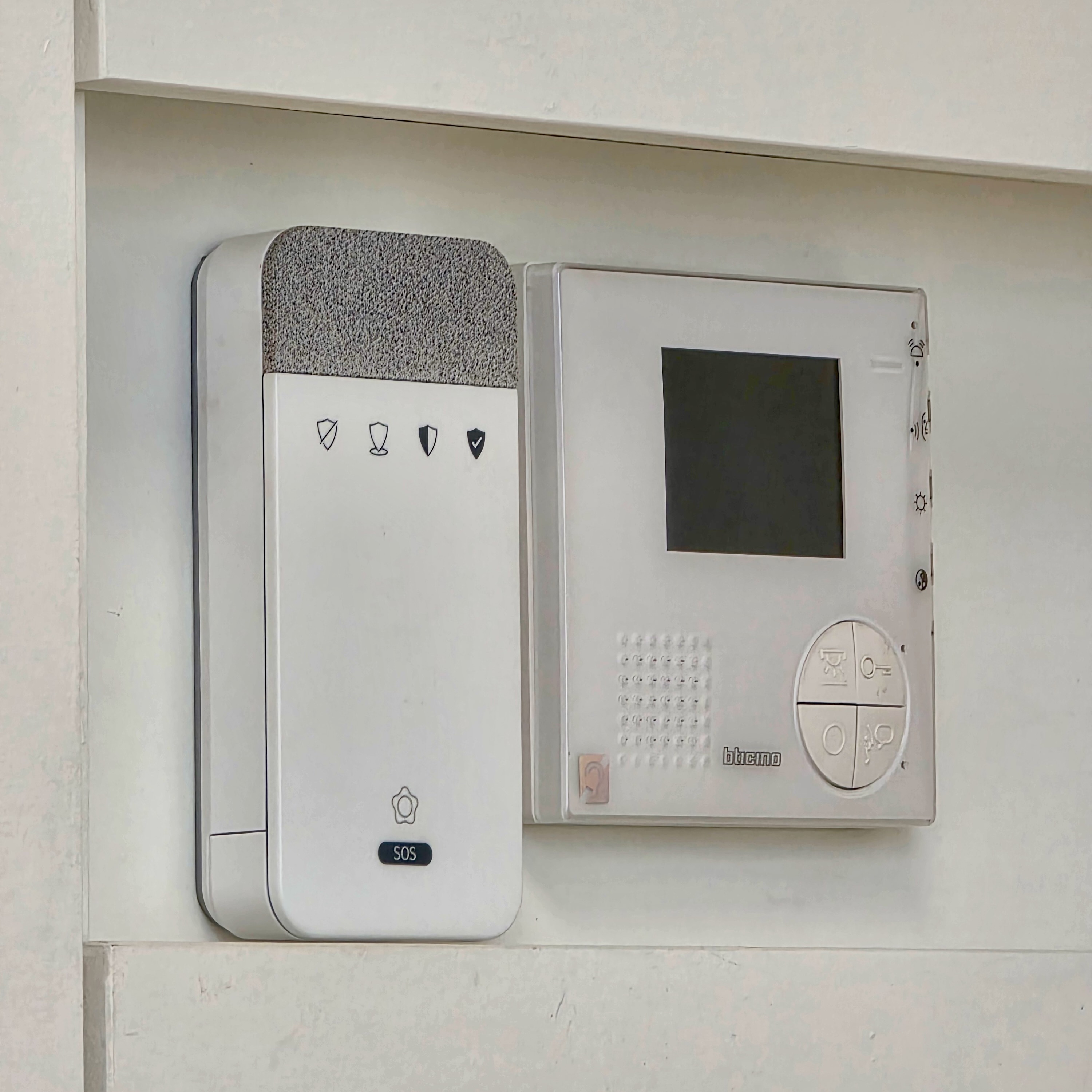 Centrale d'alarme blanche fixée au mur, avec bouton SOS et voyants indicateurs