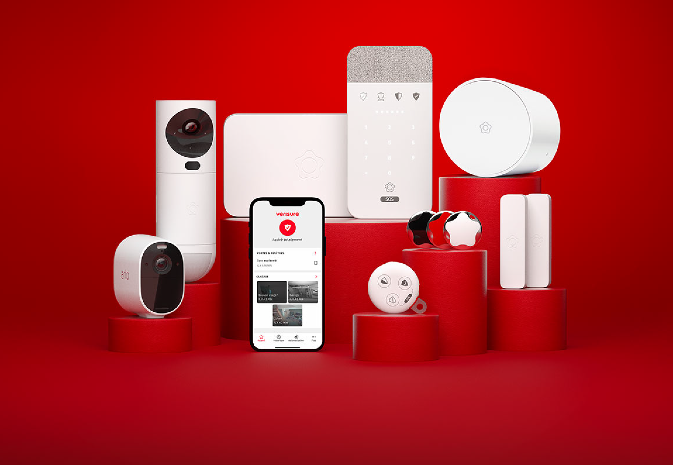 Équipements de télésurveillance Verisure présentés sur socles rouges : caméras, panneau de commande à clavier, centrale et capteurs blancs.