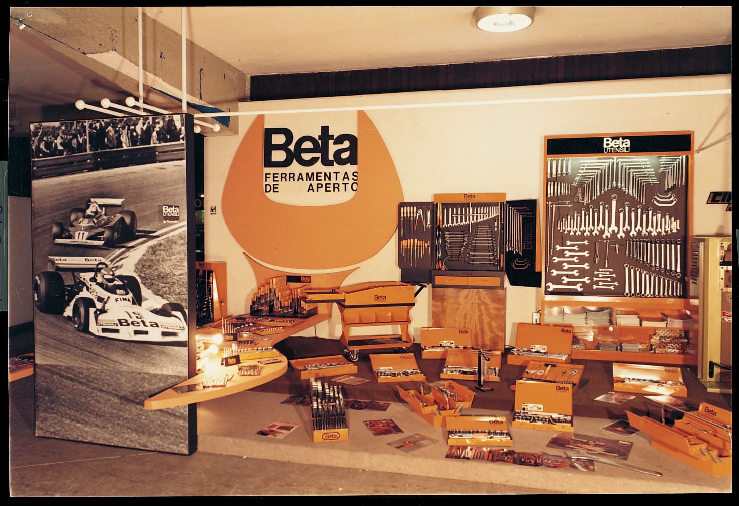 Stand d’exposition Beta avec logo orange et panneaux d’outils dans une archive de 1971