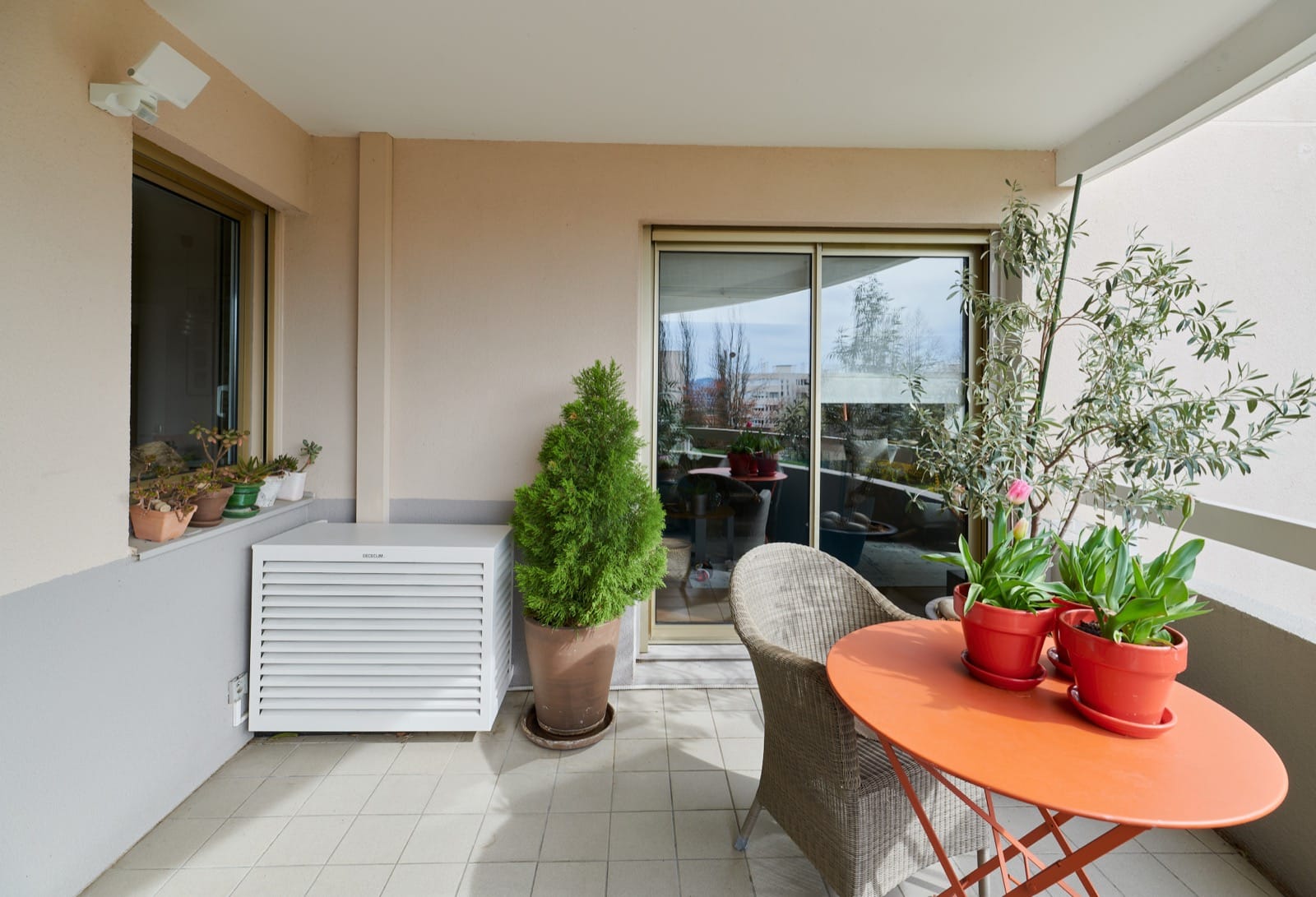 Unité extérieure Daikin intégrée sur un balcon avec plantes et mobilier