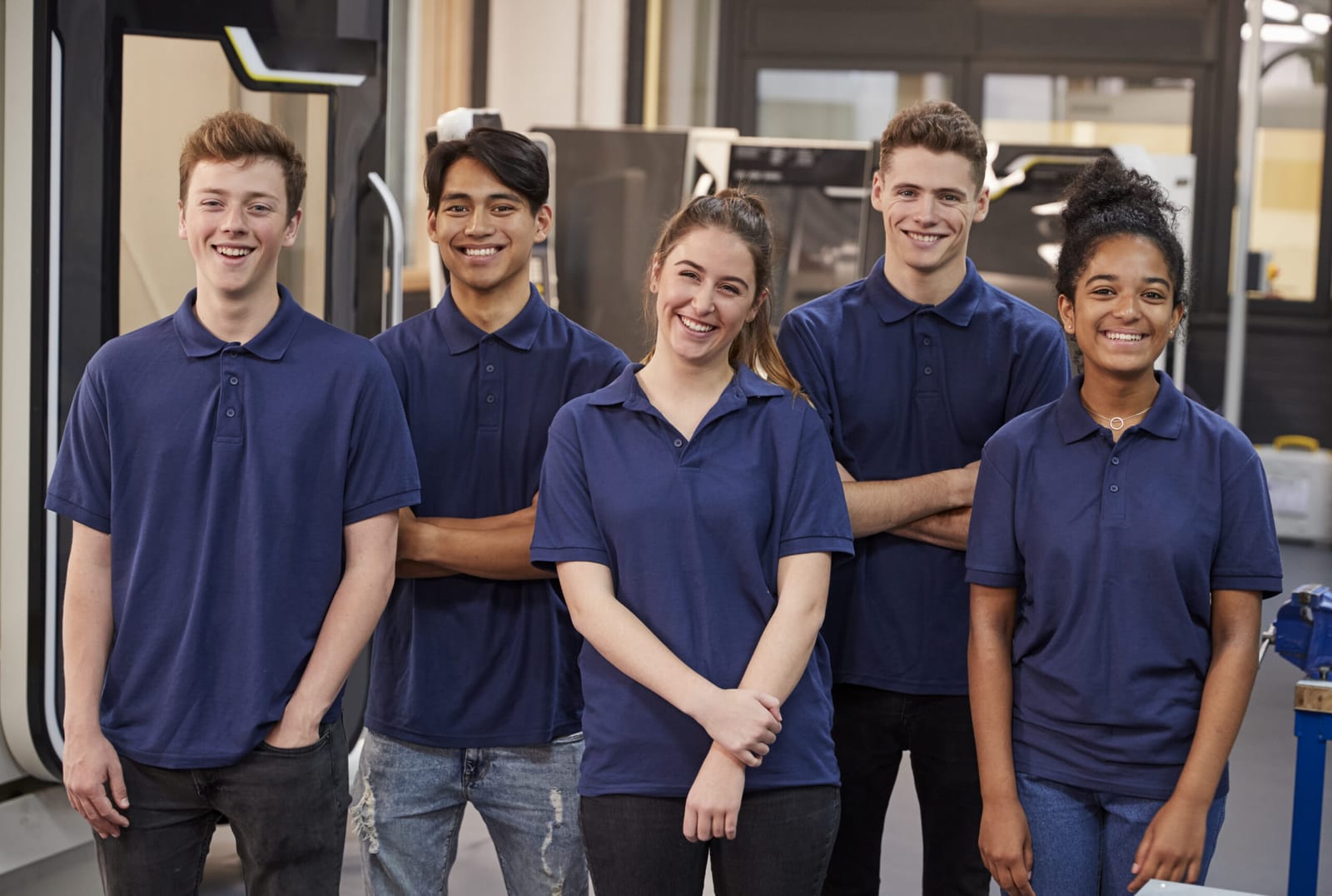 Groupe d'apprentis en tenue de travail dans un atelier industriel