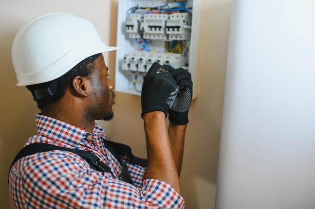 Électricien intervenant sur un tableau électrique