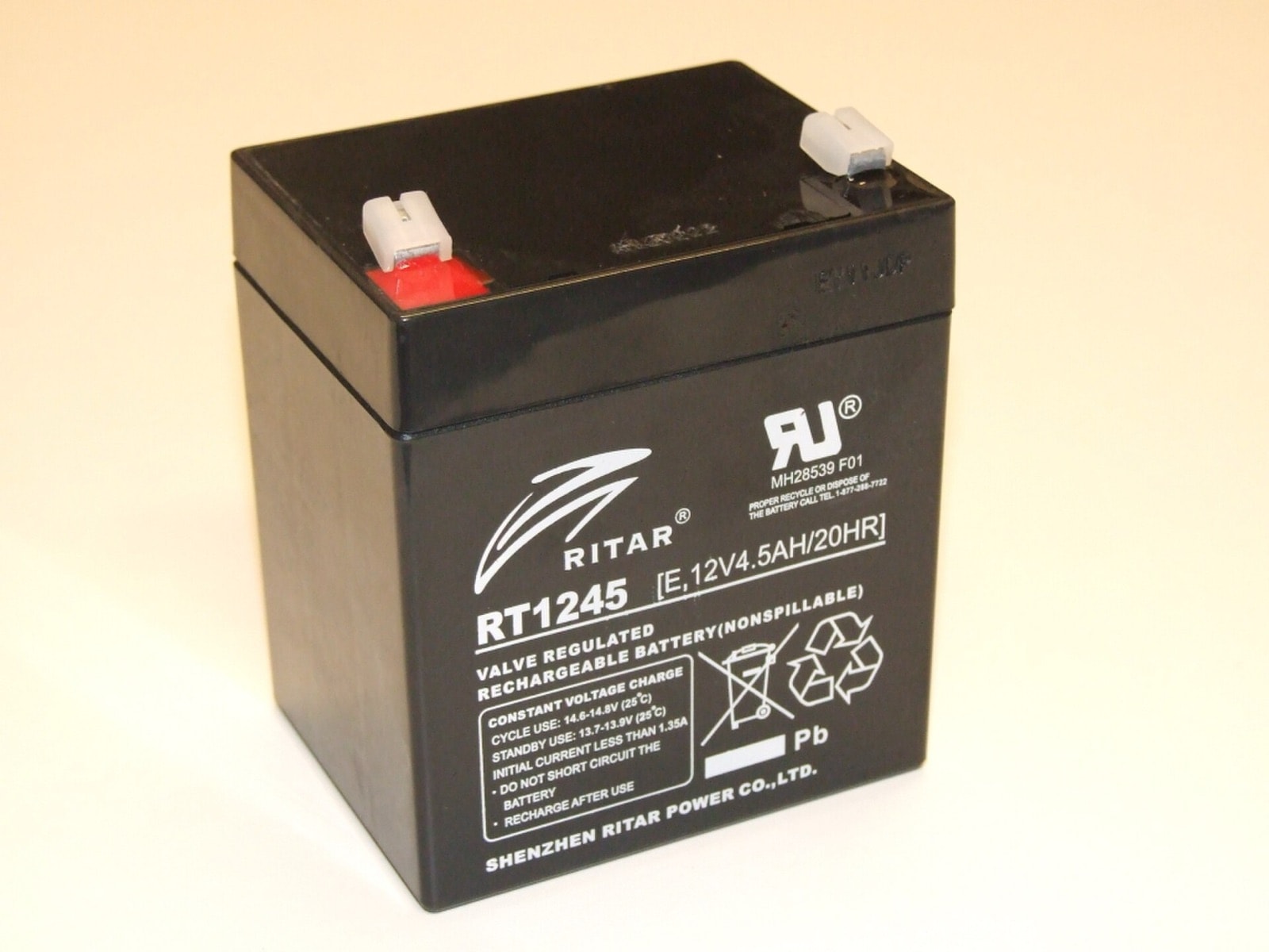Batterie plomb étanche RITAR RT1245 12 V vue de dessus, deux cosses faston dont celle de gauche porte un repère rouge