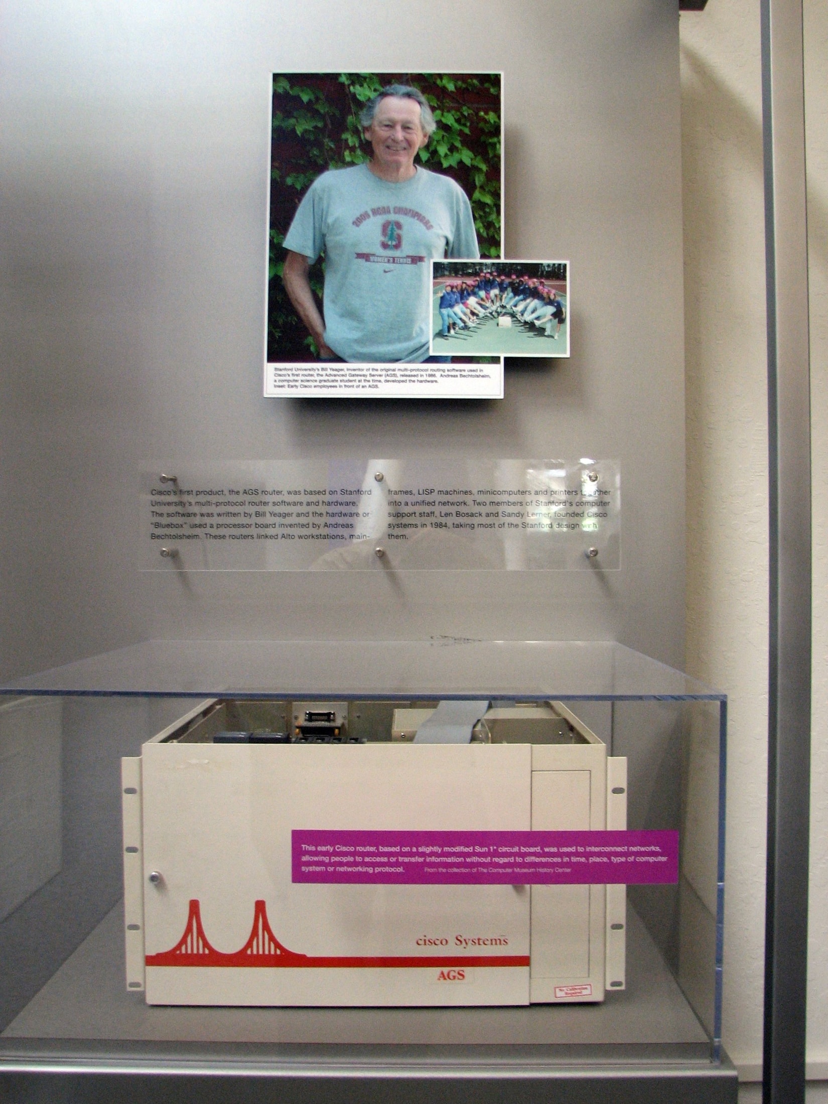 Routeur Cisco AGS beige de 1986 présenté en vitrine avec son logo à deux tours