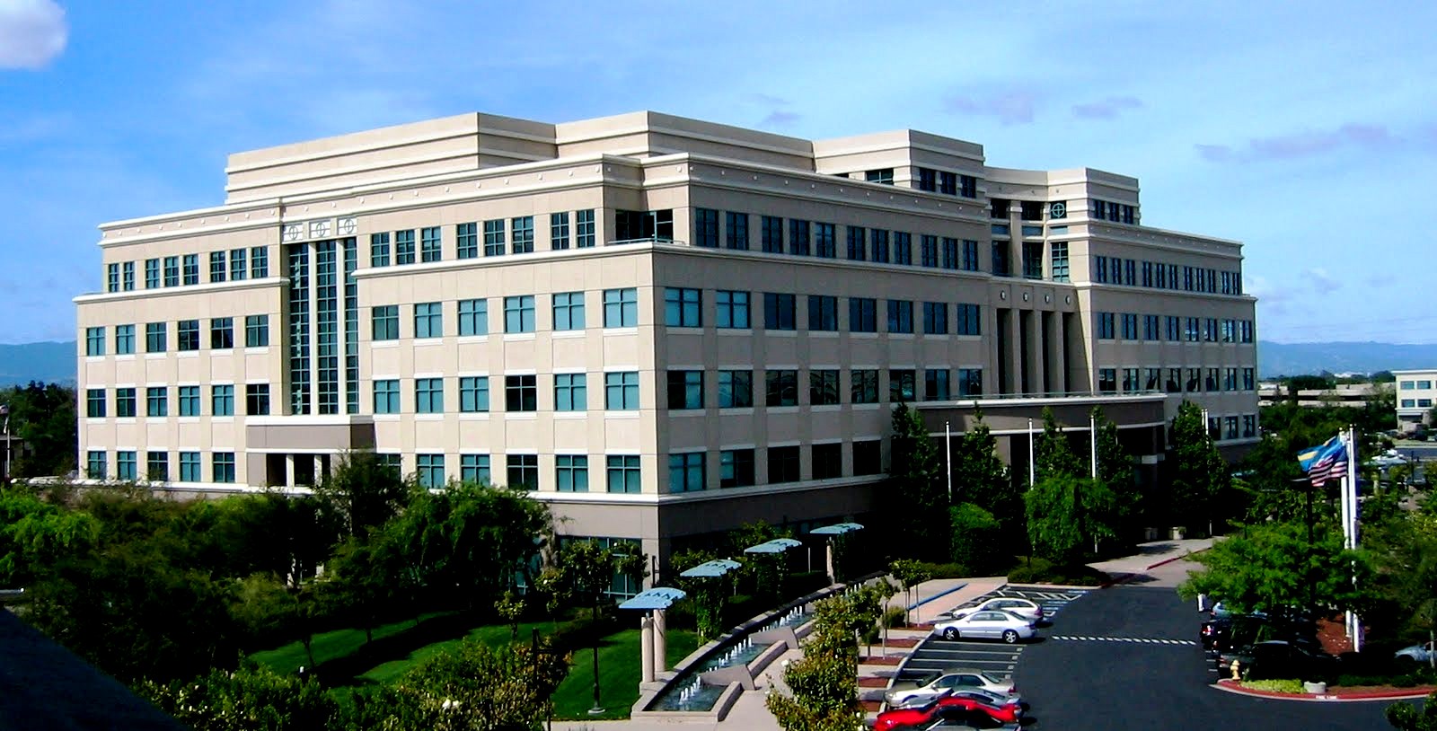 Bâtiment 10 du siège historique de Cisco Systems à San Jose, avec drapeaux et parking