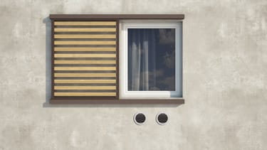 Façade avec deux grilles rondes positionnées sous une fenêtre