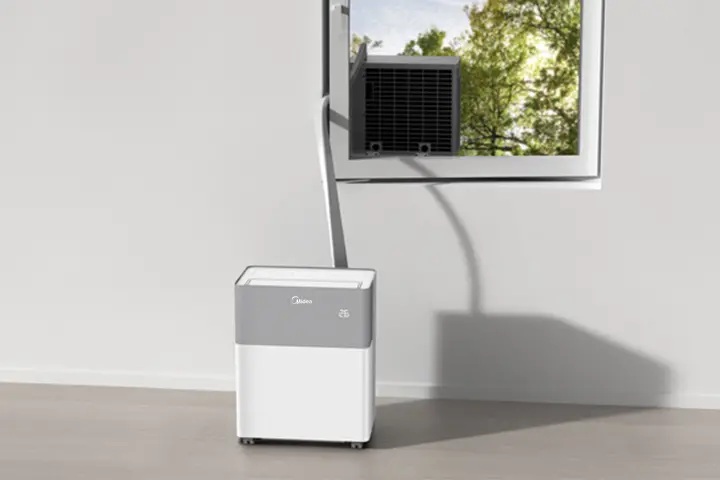 Midea PortaSplit installé entre une unité intérieure au sol et une unité extérieure dans une fenêtre