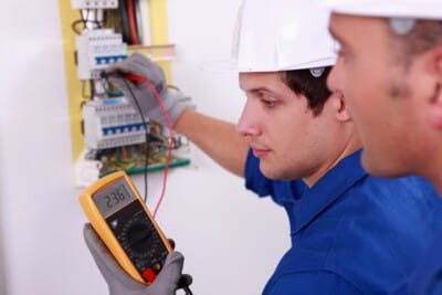 Électricien contrôlant un tableau électrique avec un multimètre