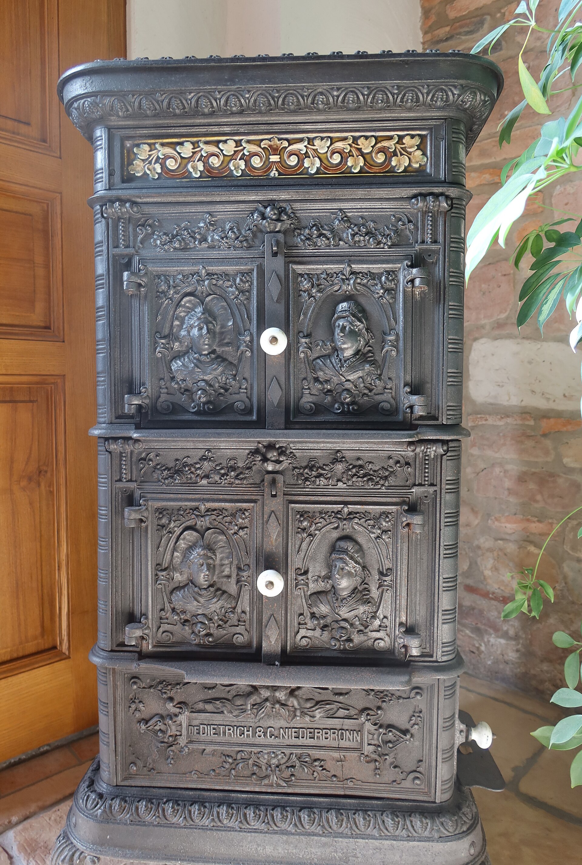 Poêle en fonte noir orné de bas-reliefs avec inscription De Dietrich & C. Niederbronn