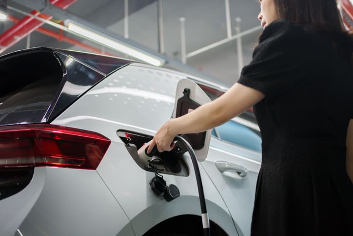 Voiture électrique branchée dans un parking couvert