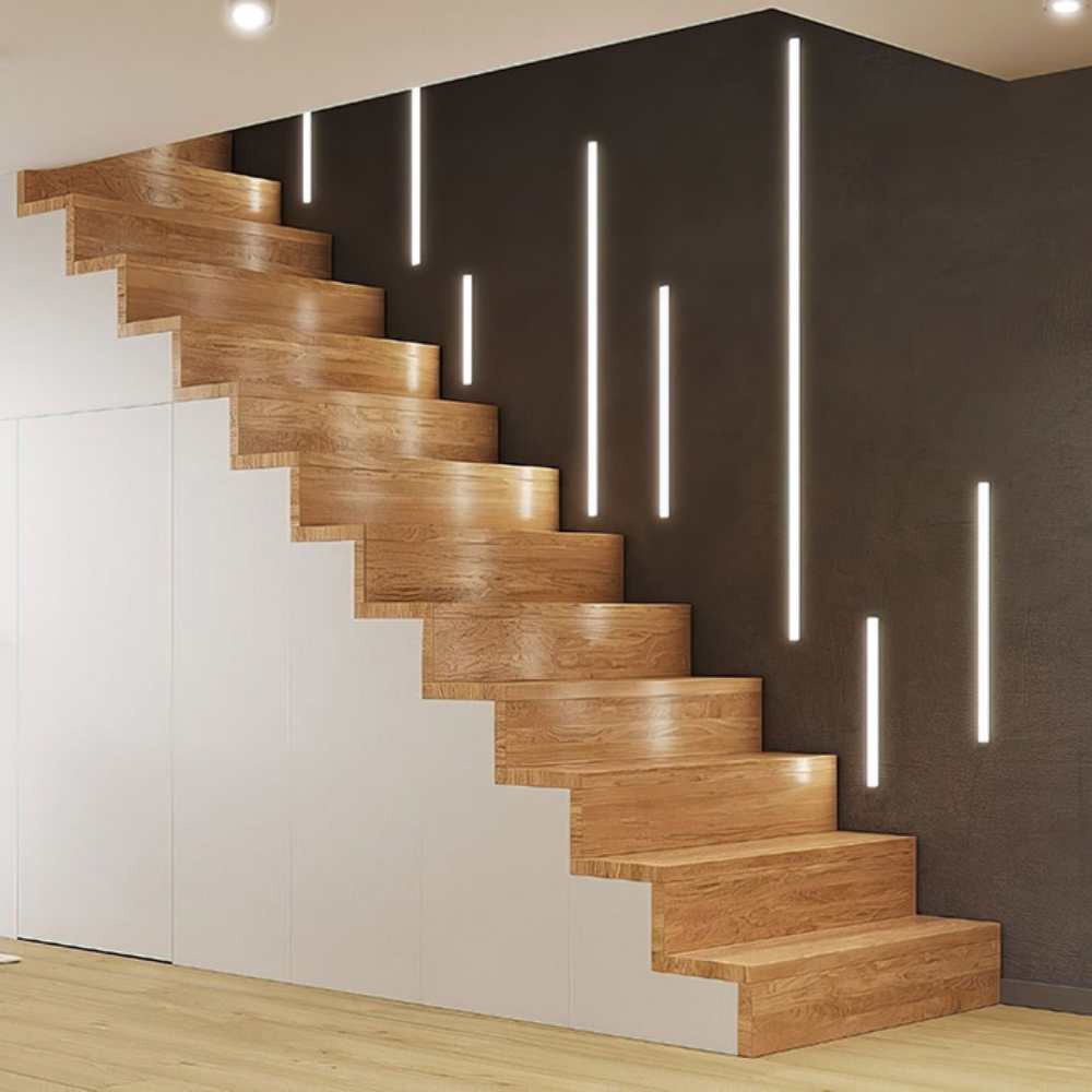 Escalier en bois avec contremarches blanches et bandes LED verticales installées sur le mur sombre adjacent