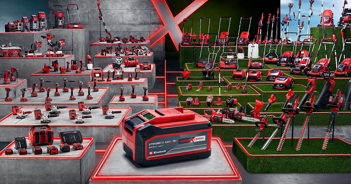 Une batterie Einhell Power X-Change au premier plan devant une large gamme d’outils de bricolage et de jardinage de la marque.