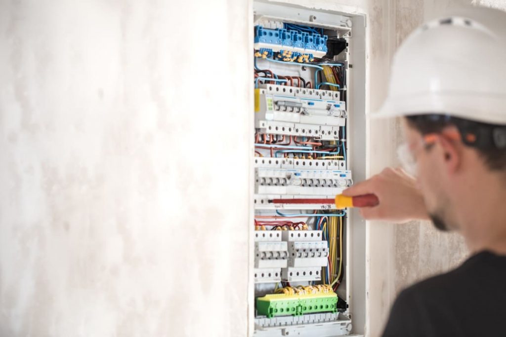 Électricien contrôlant un tableau électrique pendant un diagnostic