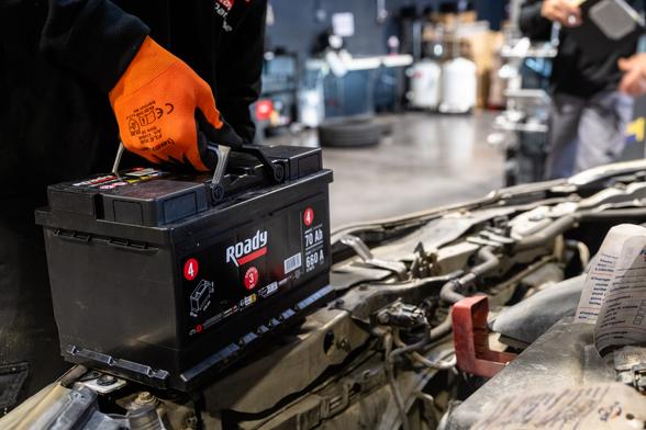 Technicien tenant une batterie automobile déposée